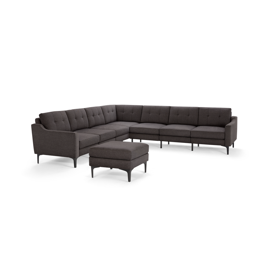 Dark gray L-shaped sectional sofa with button-tufted back cushions and matching ottoman on black legs.