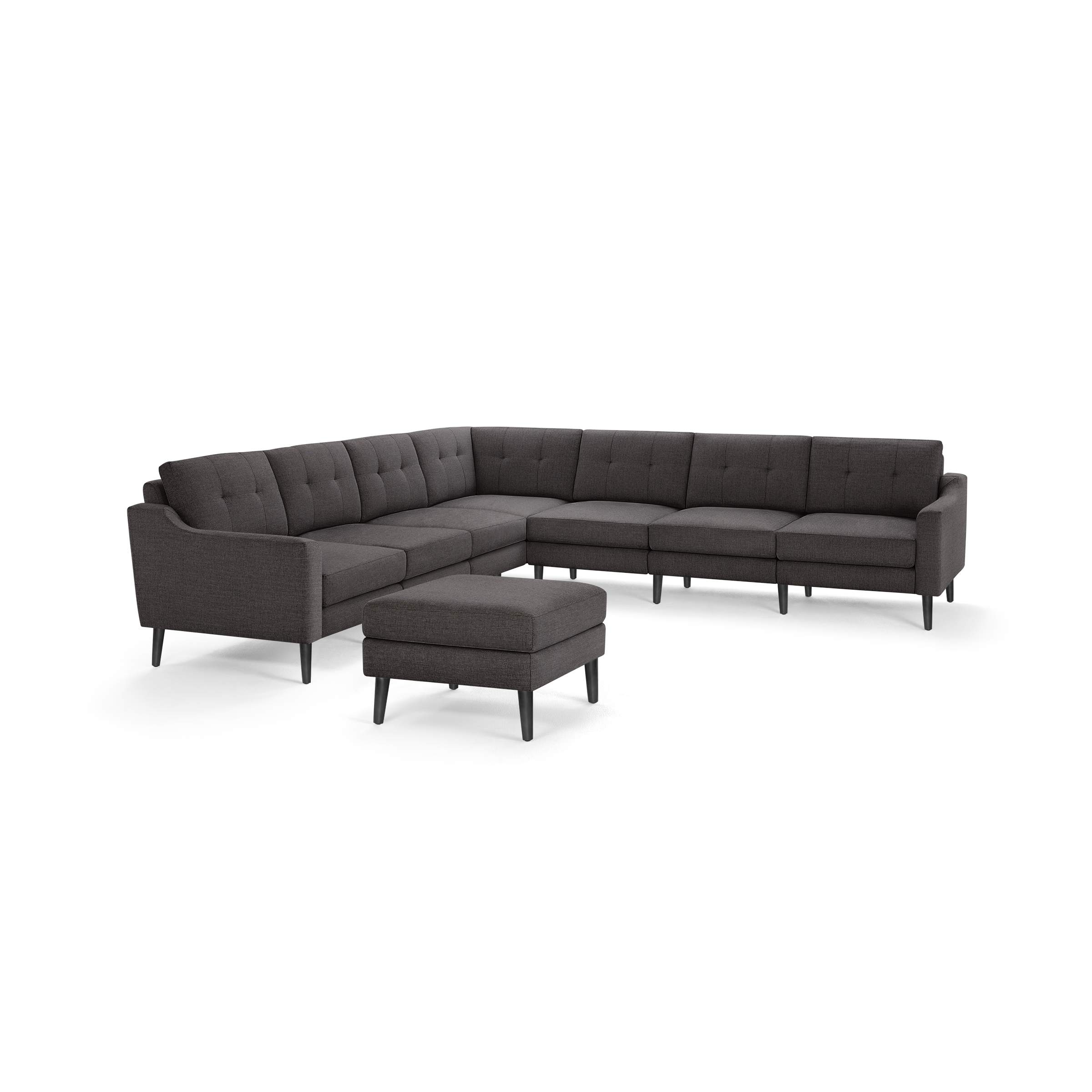Dark gray L-shaped sectional sofa with tufted cushions and matching ottoman, supported by black wooden legs.