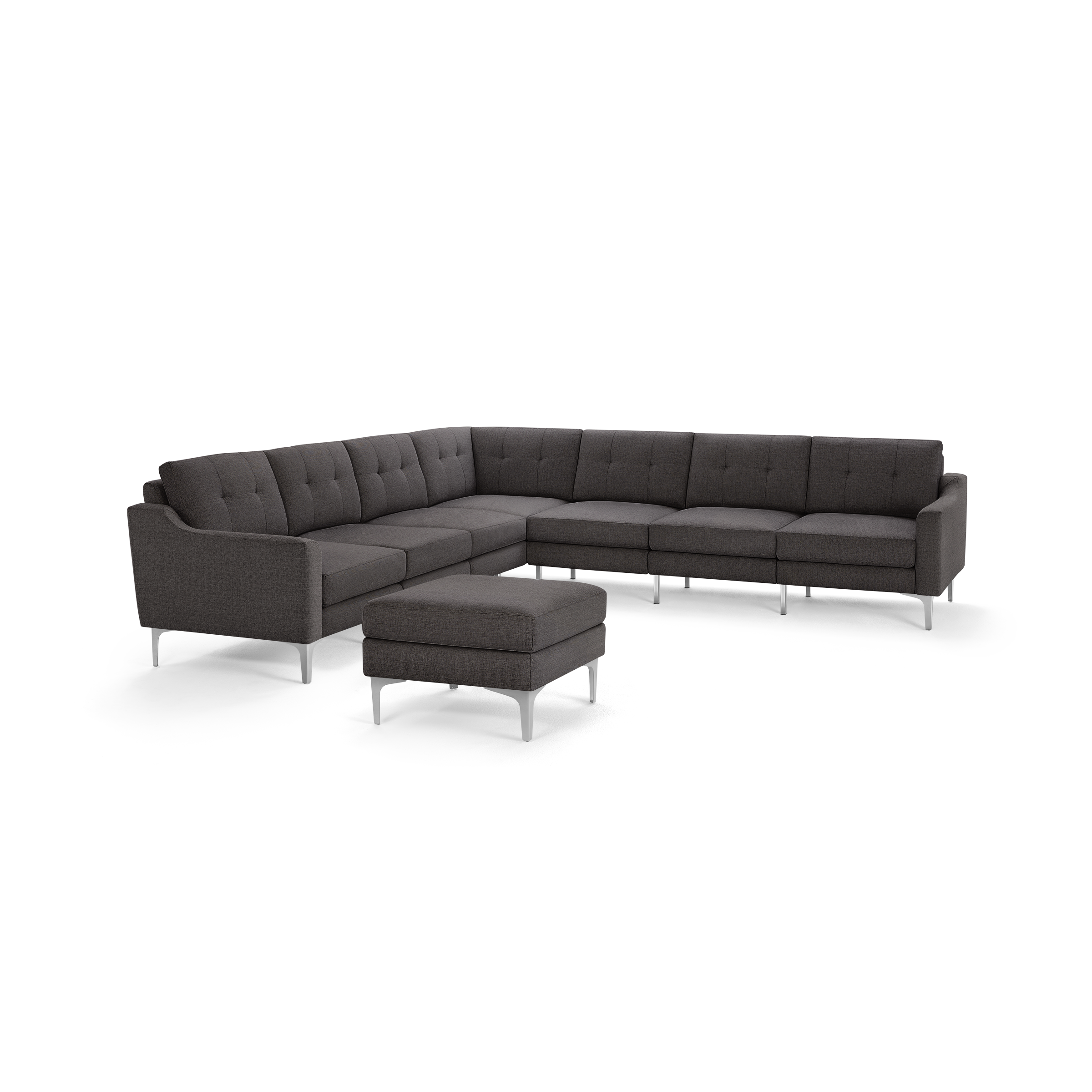 Dark gray fabric sectional sofa with tufted back cushions and matching ottoman, supported by sleek silver metal legs.