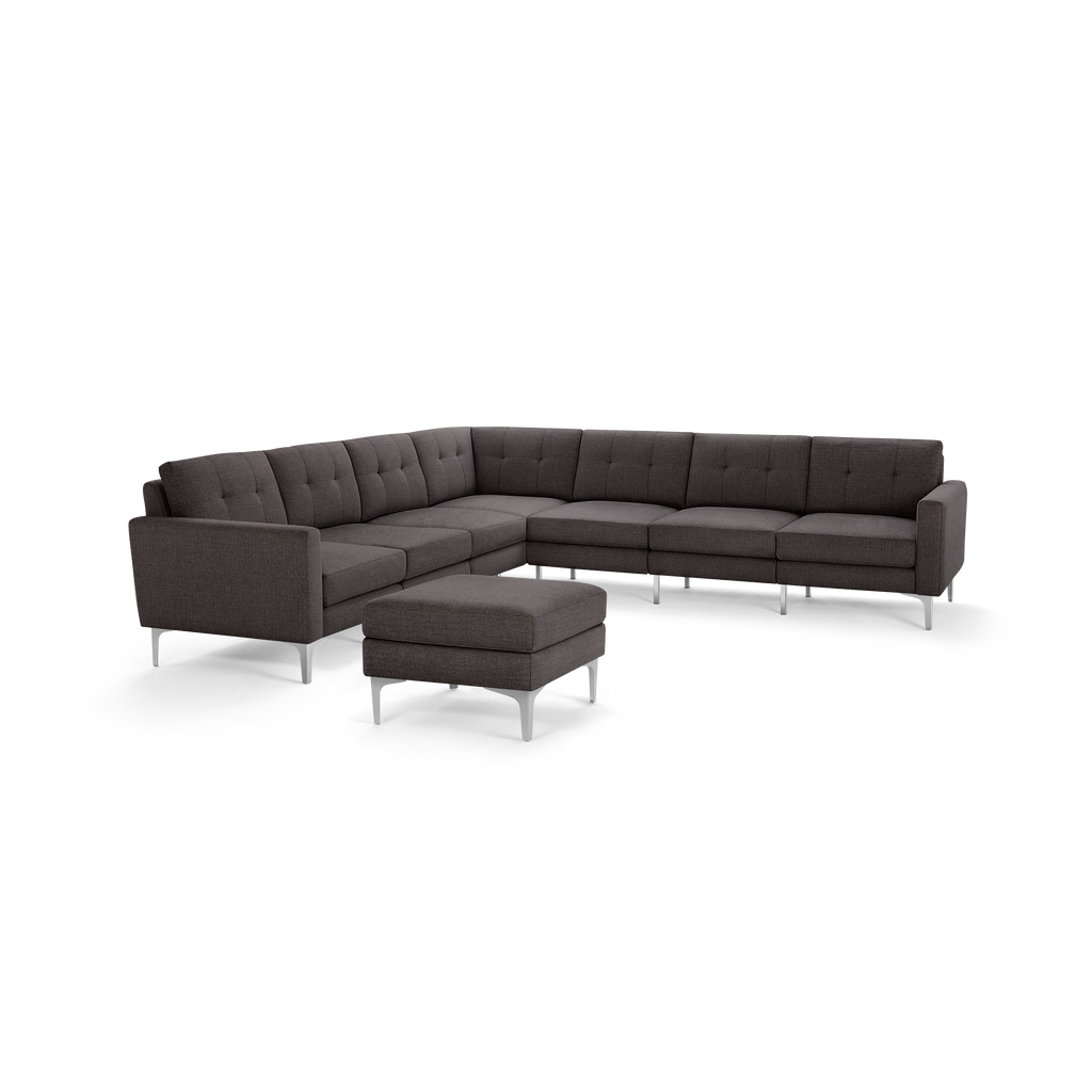 Dark gray tufted fabric L-shaped sectional sofa with metal legs, featuring a matching ottoman.