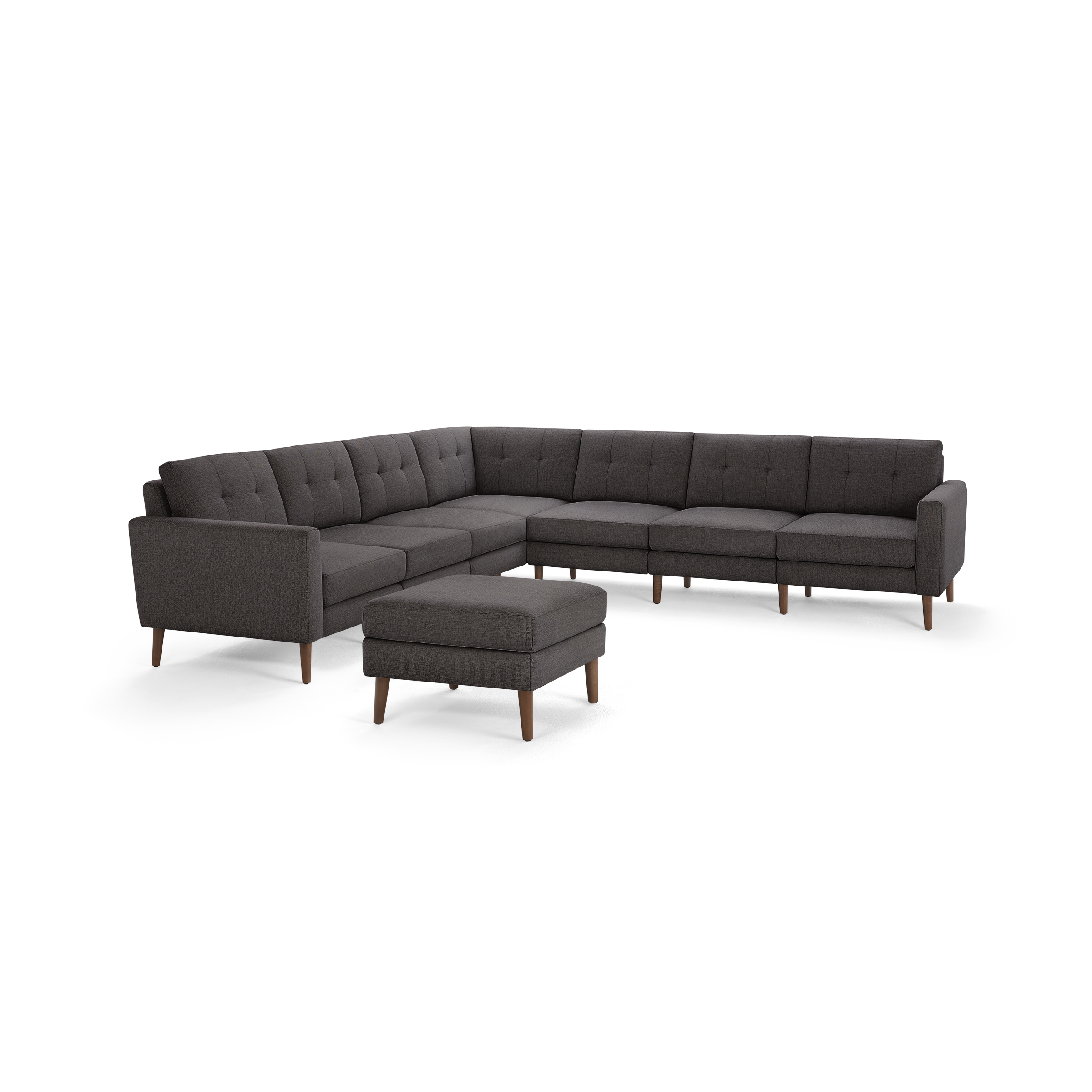 Dark gray fabric upholstered mid-century modern sectional sofa with tufted back cushions and matching ottoman, supported by wooden legs.