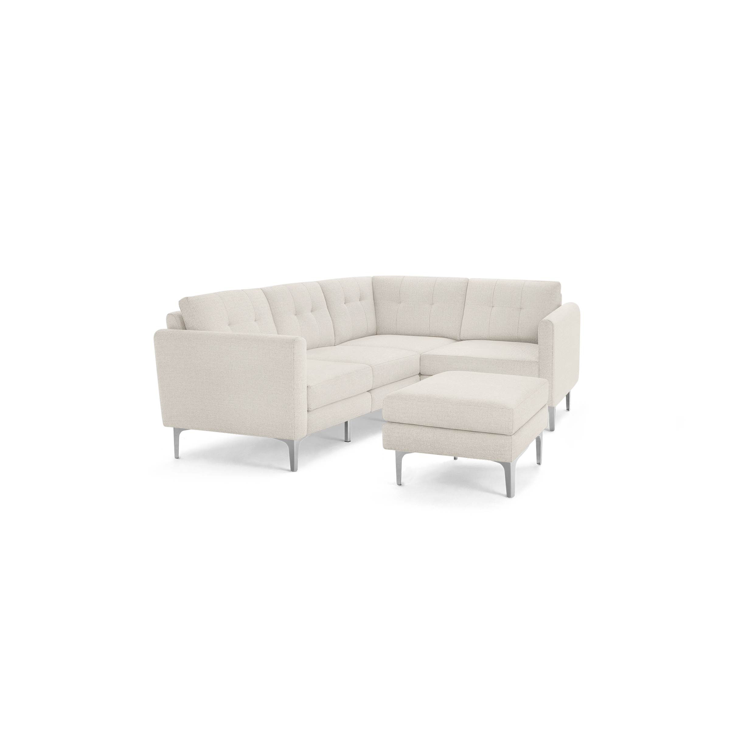 Beige fabric L-shaped sectional sofa with tufted back cushions and matching ottoman on metal legs, isolated on black background.