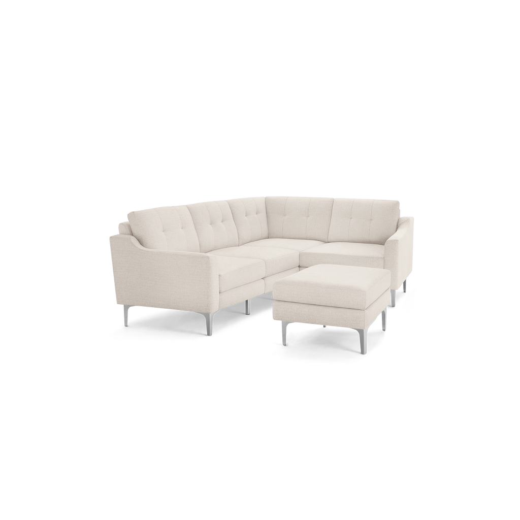 Light beige upholstered modern sectional sofa with tufted back cushions and matching ottoman on metal legs.
