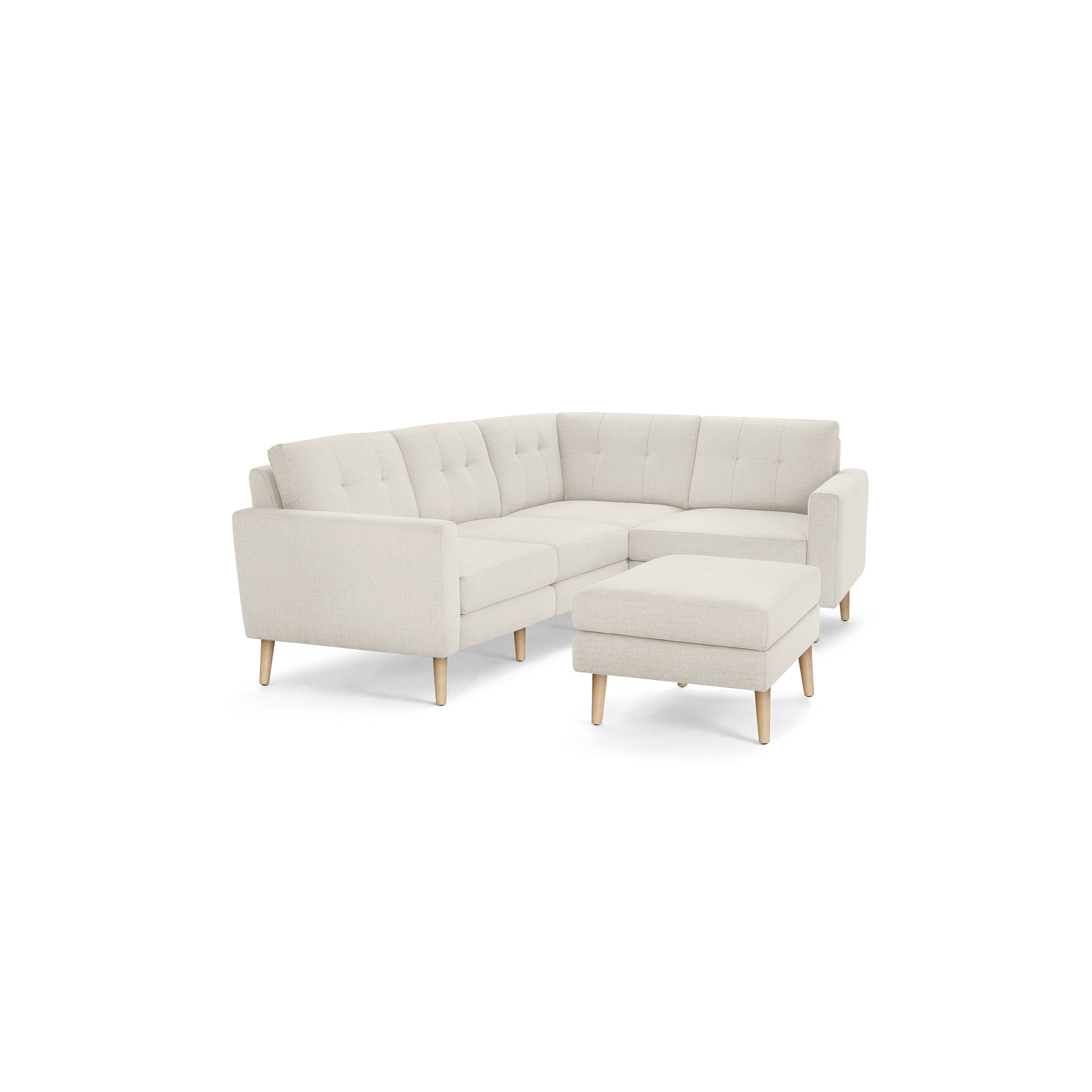 Beige fabric L-shaped sectional sofa with tufted back cushions and matching ottoman, supported by light wooden legs.