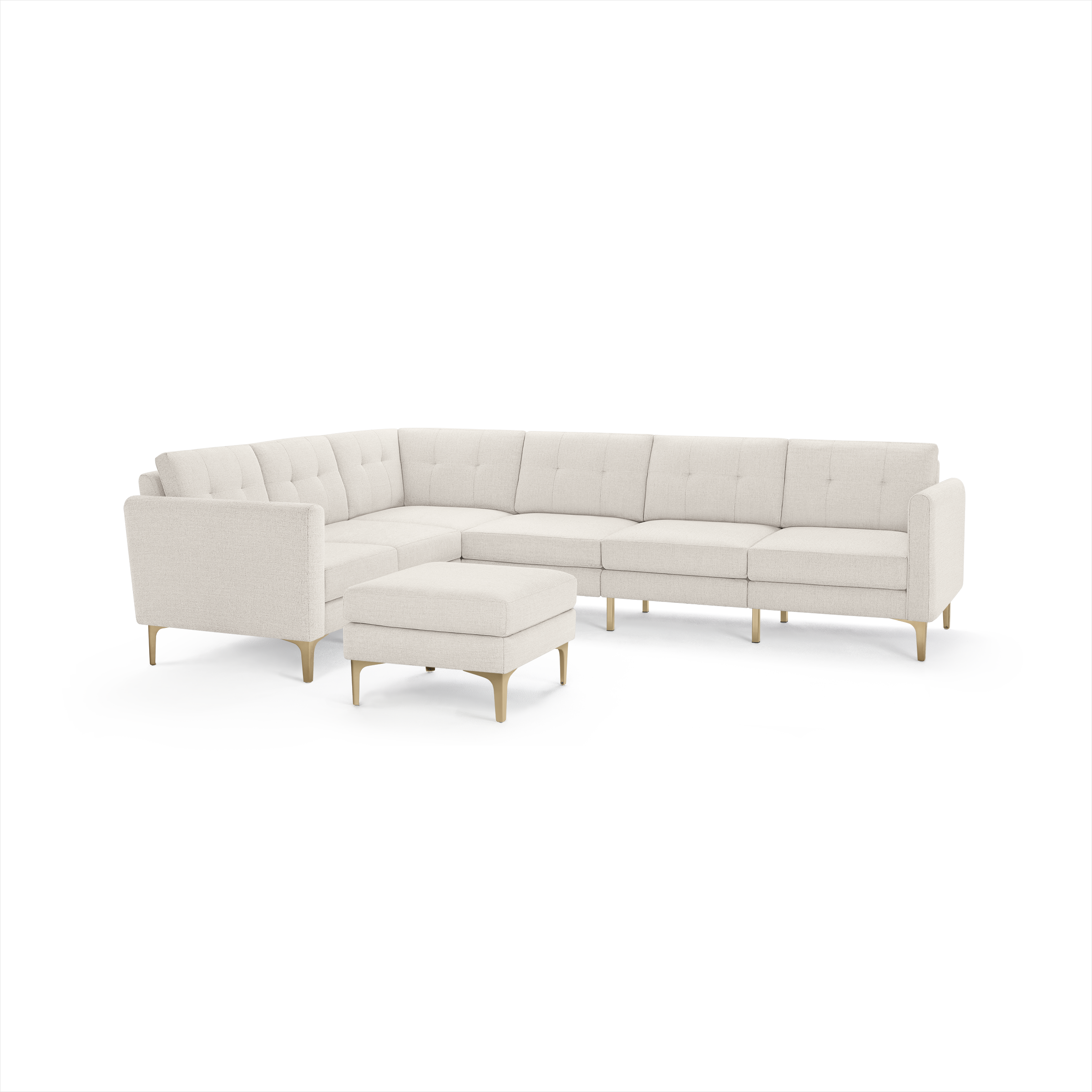 Cream-colored L-shaped sectional sofa with tufted back cushions and matching ottoman, featuring slim light wooden legs.