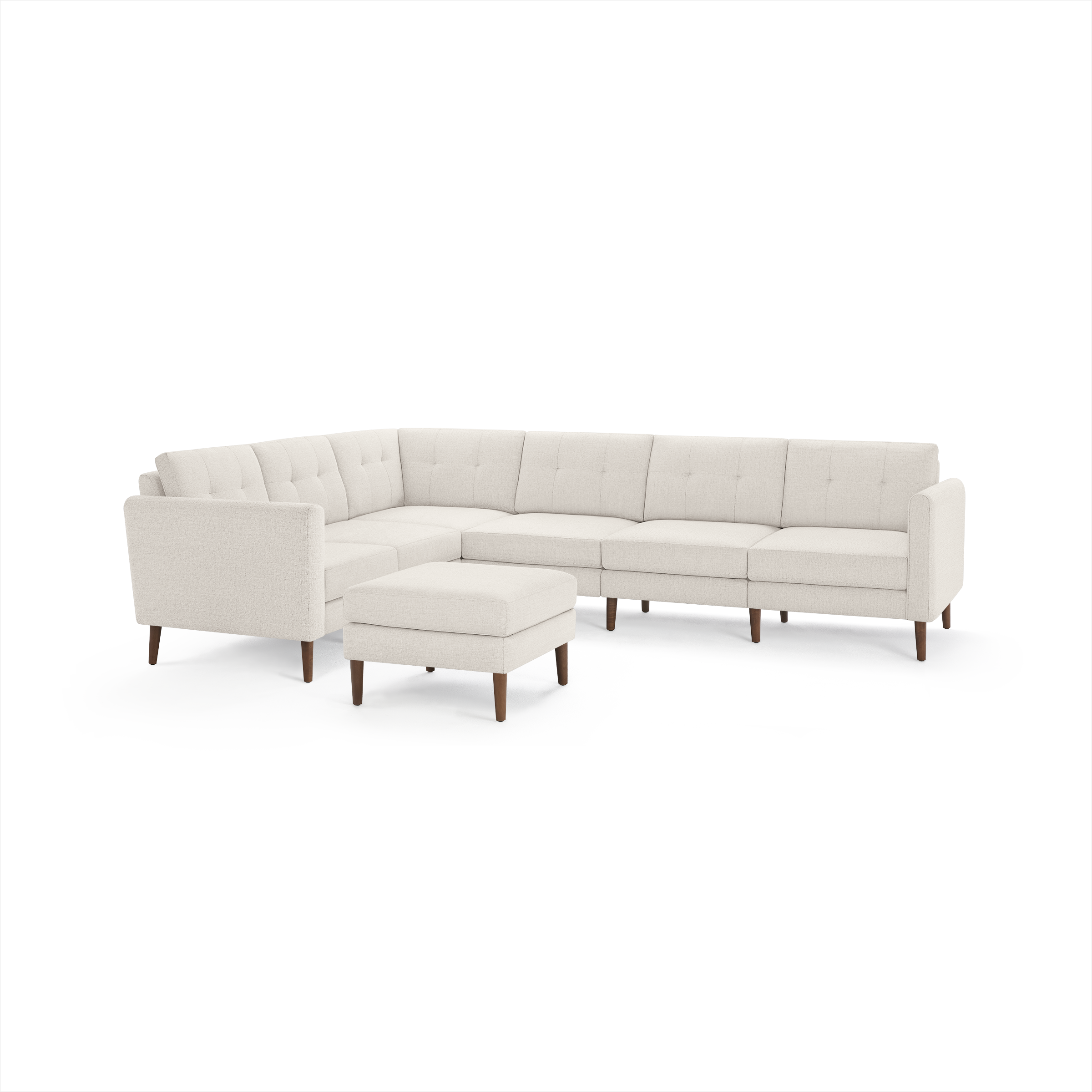 Beige L-shaped sectional sofa with tufted cushions, wooden legs, and matching square ottoman, modern mid-century design.
