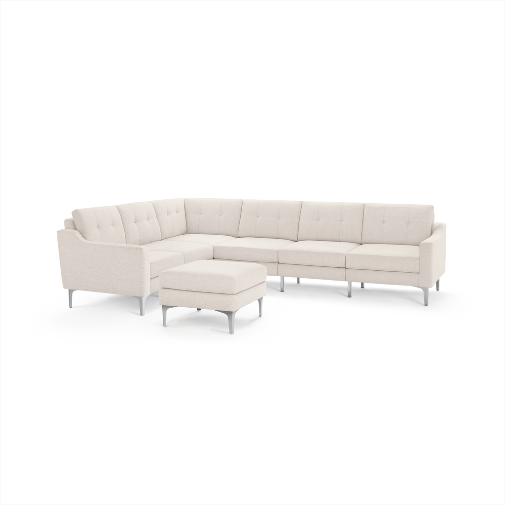 Modern L-shaped cream fabric sectional sofa with tufted cushions and matching ottoman, supported by sleek metal legs.