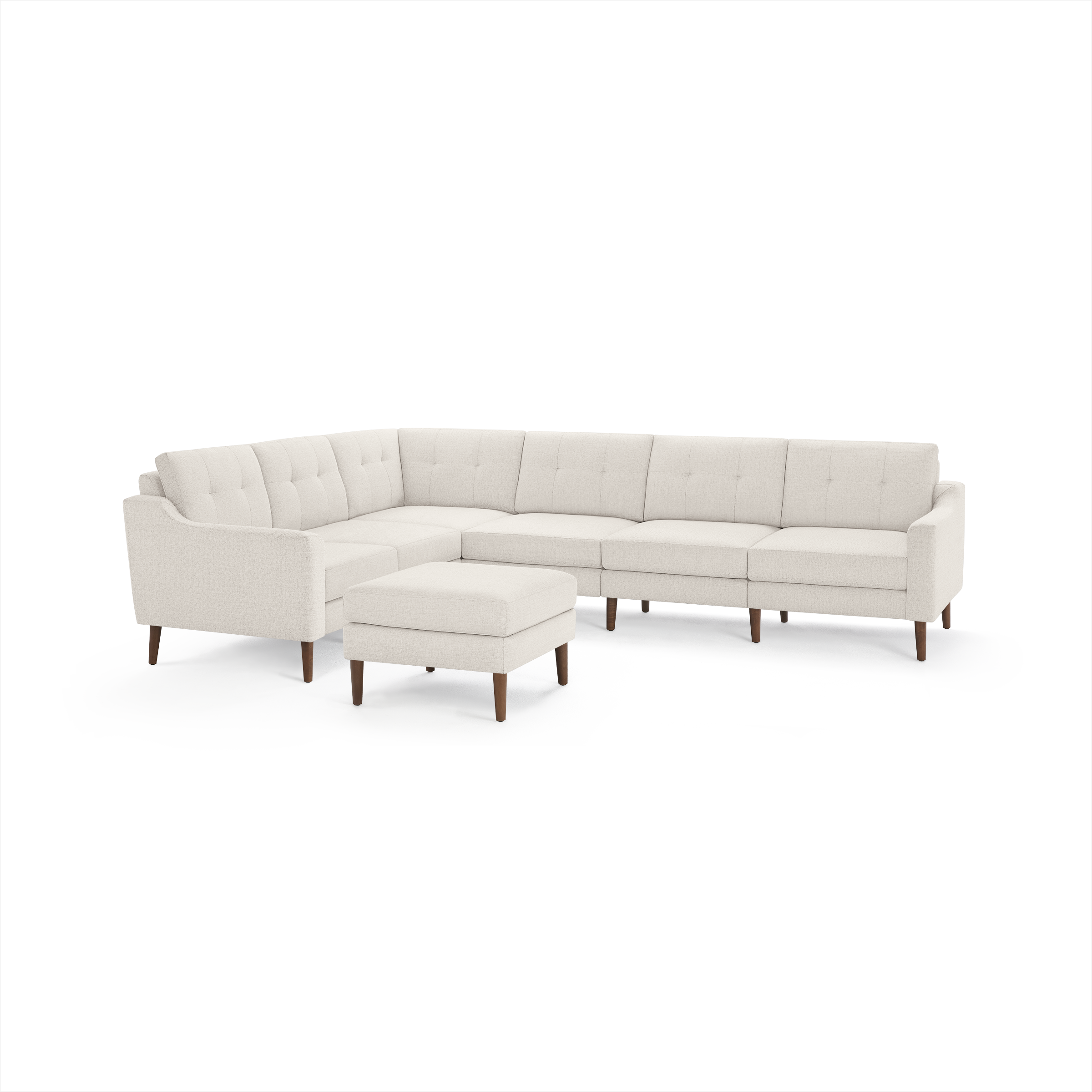 Beige L-shaped sectional sofa with tufted back cushions, wooden legs, and a matching ottoman on a white background.