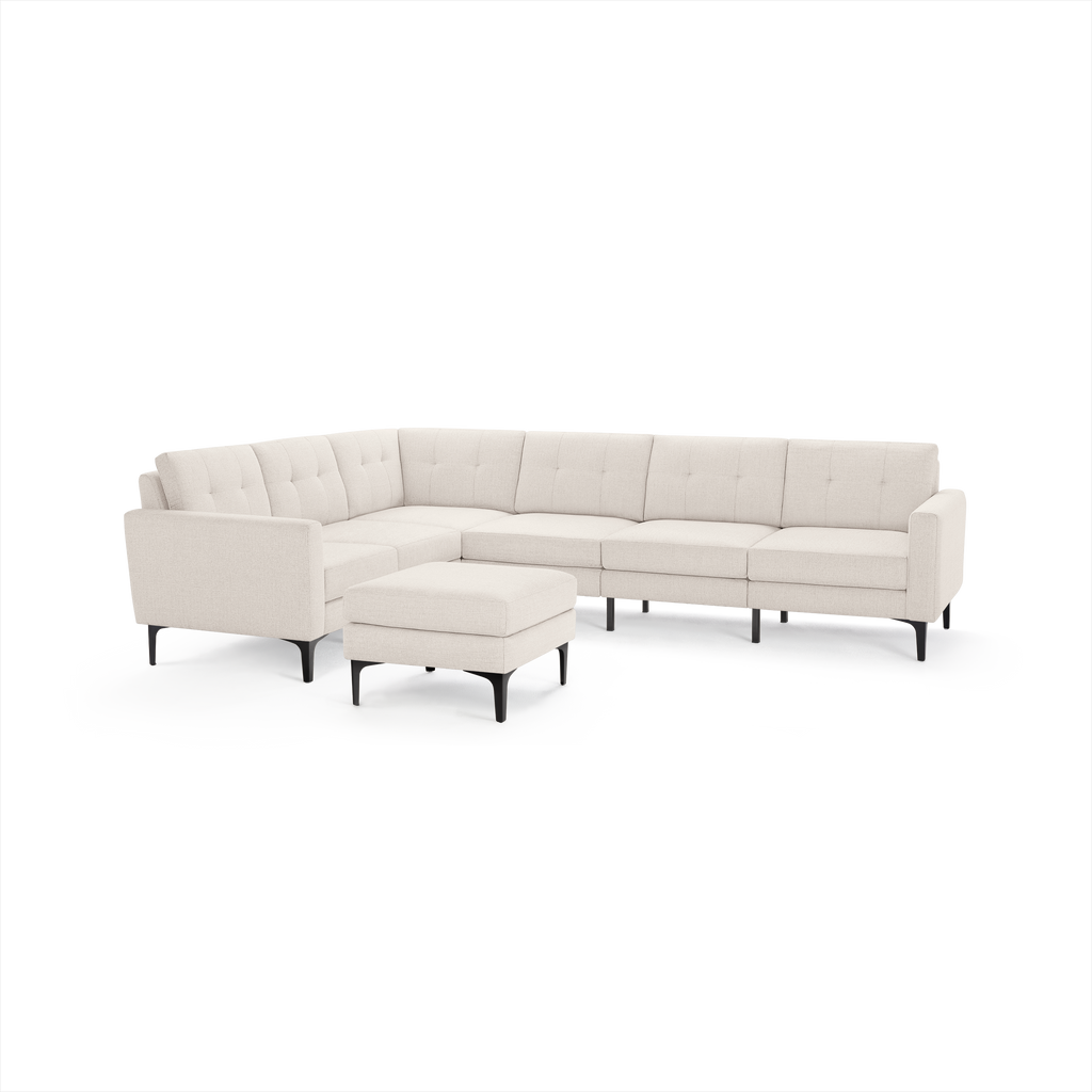 Modern beige L-shaped sectional sofa with tufted cushions and matching ottoman, featuring black tapered legs.