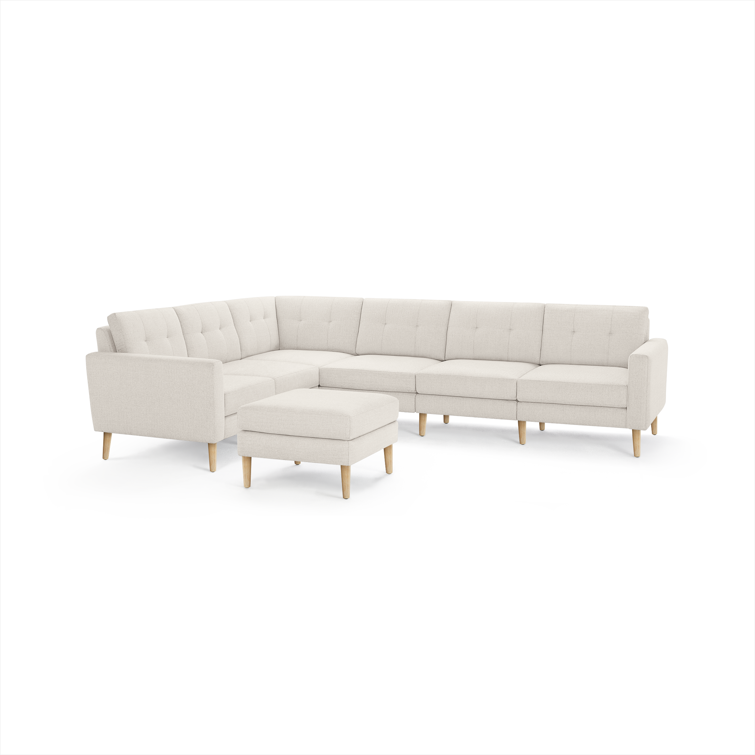 Beige L-shaped sectional sofa with tufted back cushions and matching ottoman, featuring light wooden legs.