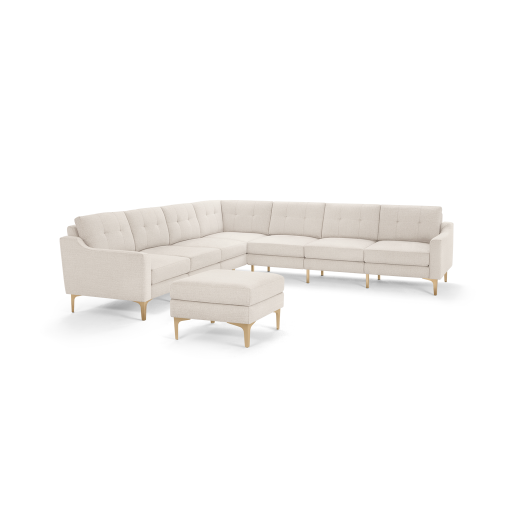 Beige L-shaped sectional sofa with tufted cushions, sleek wooden legs, and matching ottoman, modern and minimalist design.