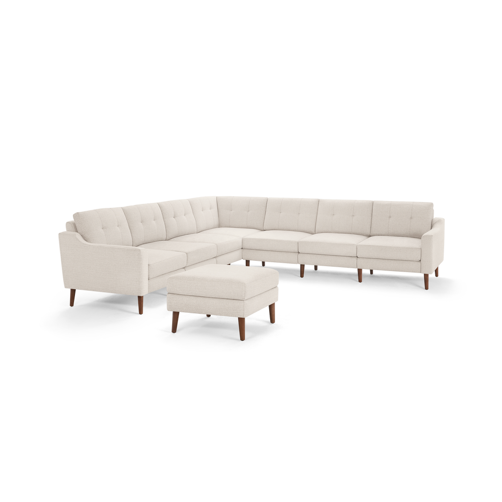 Beige mid-century modern sectional sofa with tufted cushions and wooden tapered legs, accompanied by matching ottoman.