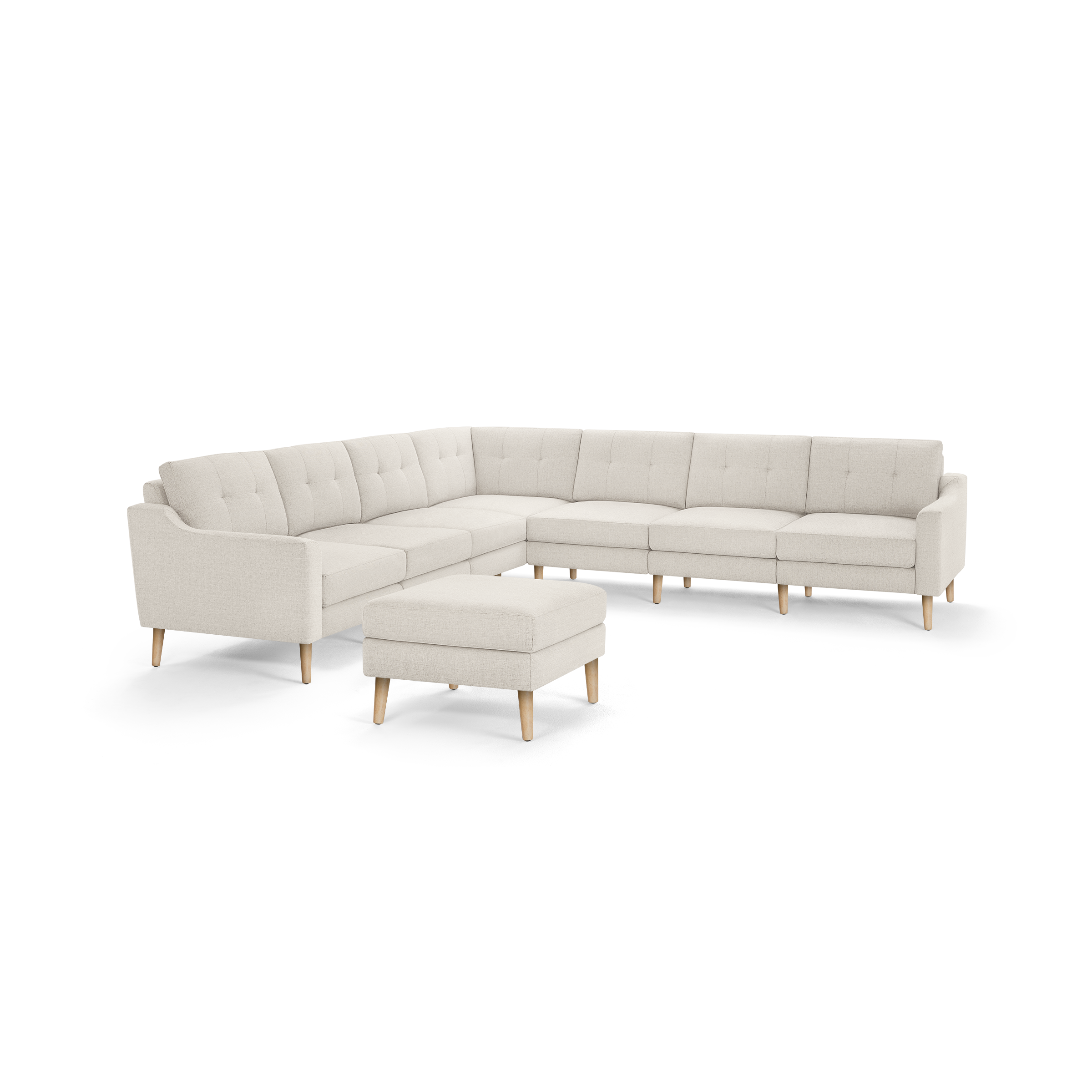 Light beige mid-century modern L-shaped sectional sofa with tufted cushions and wooden legs, accompanied by a matching rectangular ottoman.