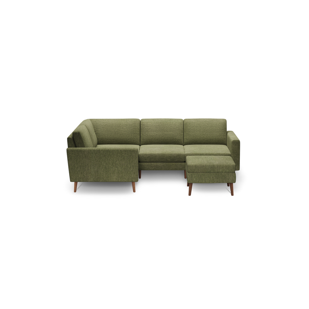 Green fabric sectional sofa with wooden legs, featuring a left armrest and a right-side chaise lounge.