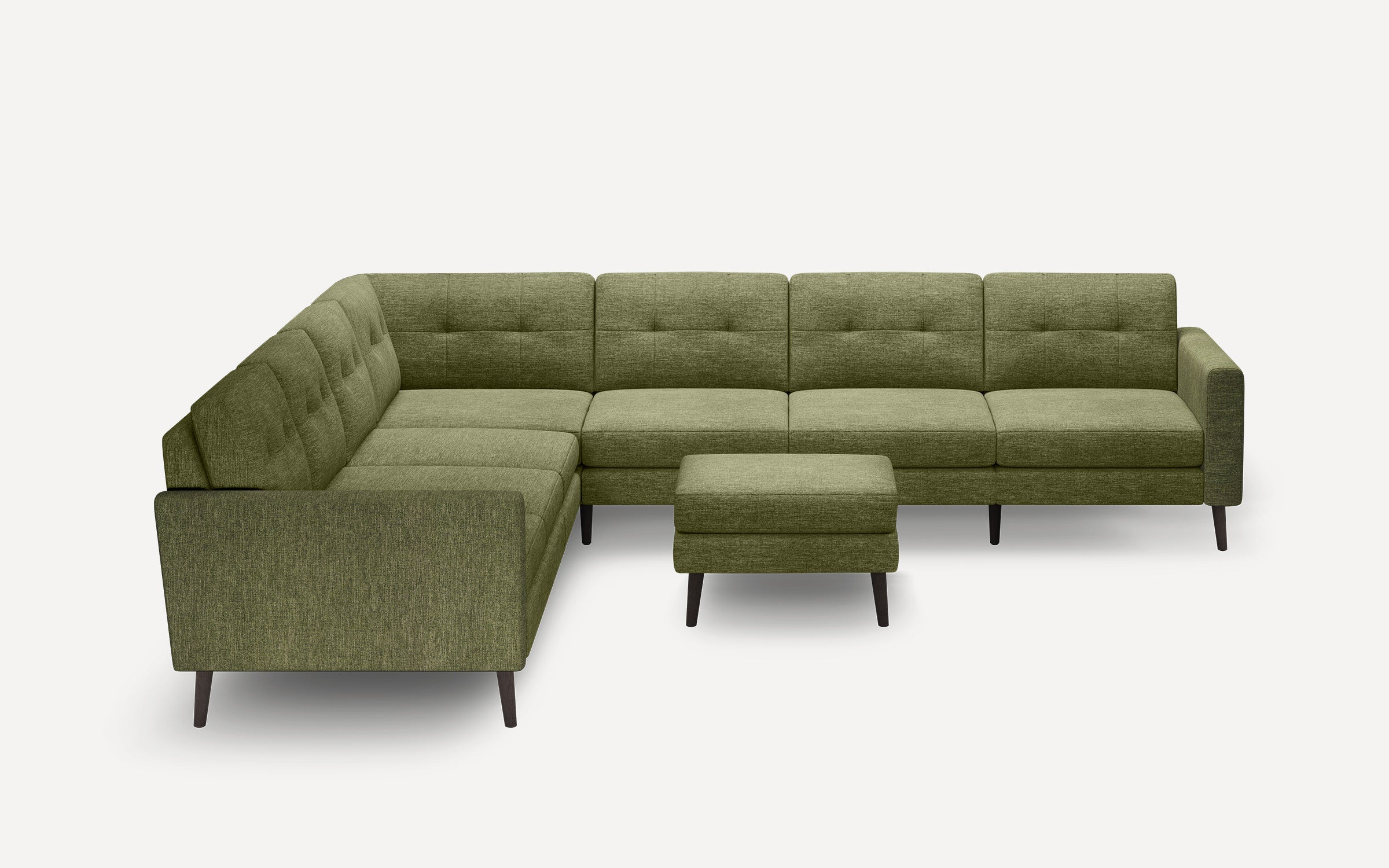 Olive green fabric sectional sofa with tufted cushions and dark wooden legs, accompanied by a matching ottoman.