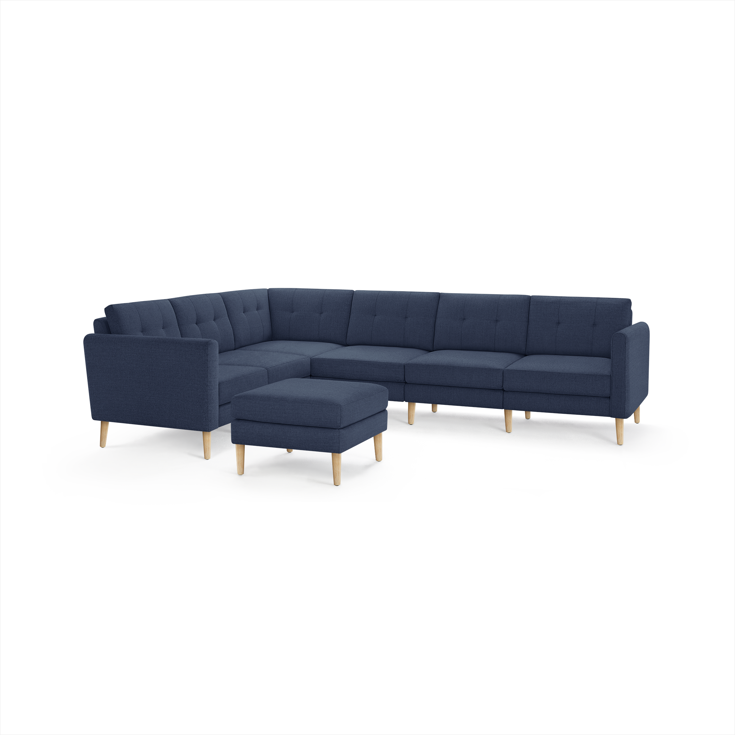 Modern navy blue fabric sectional sofa with tufted cushions and light wooden legs, including a matching ottoman.