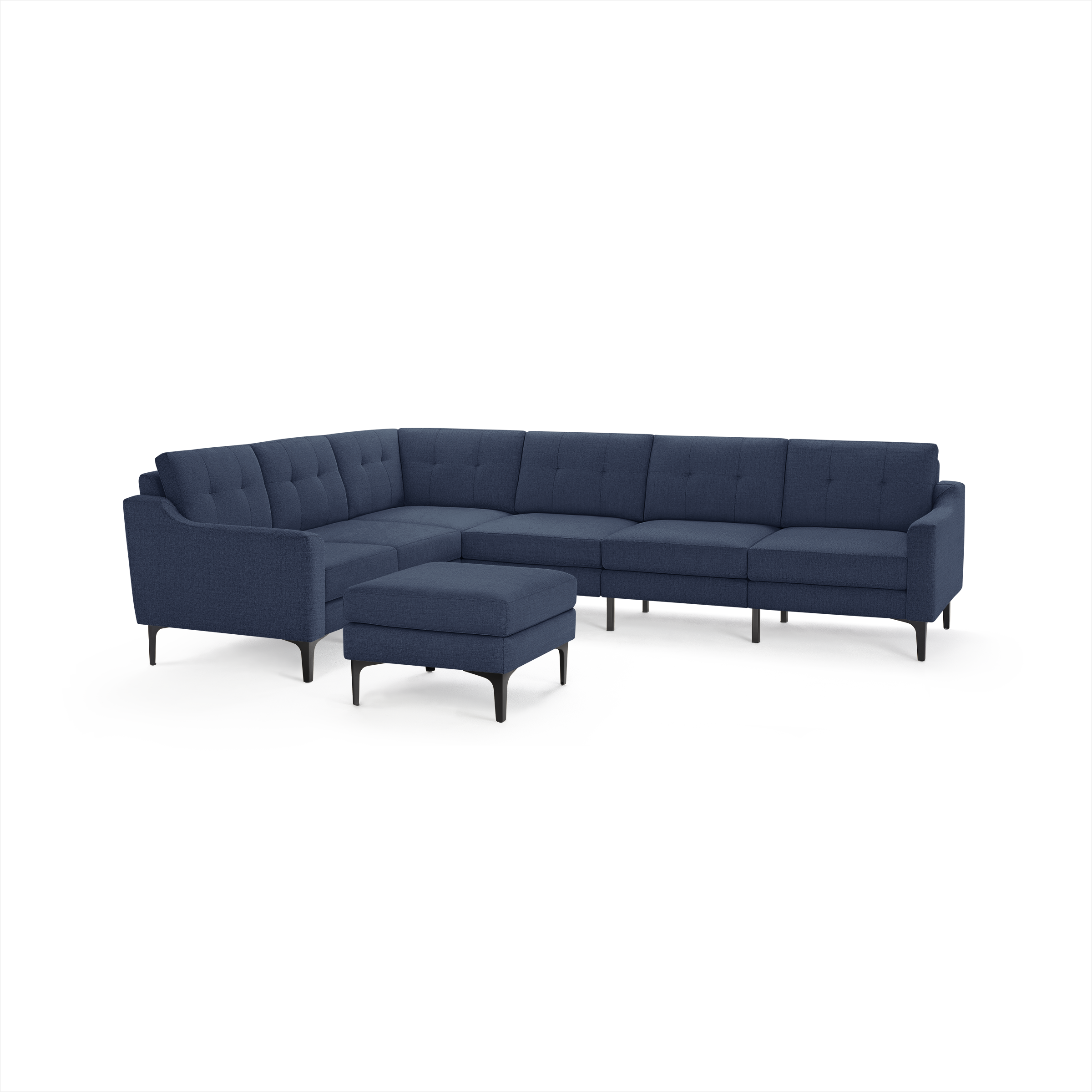 L-shaped modern sectional sofa in dark blue fabric with tufted cushions, slim black legs, and matching ottoman.
