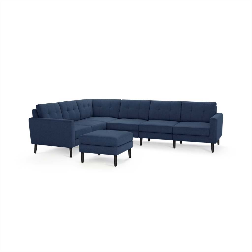 Modern navy blue fabric sectional sofa with tufted cushions and matching ottoman, supported by slender black legs.