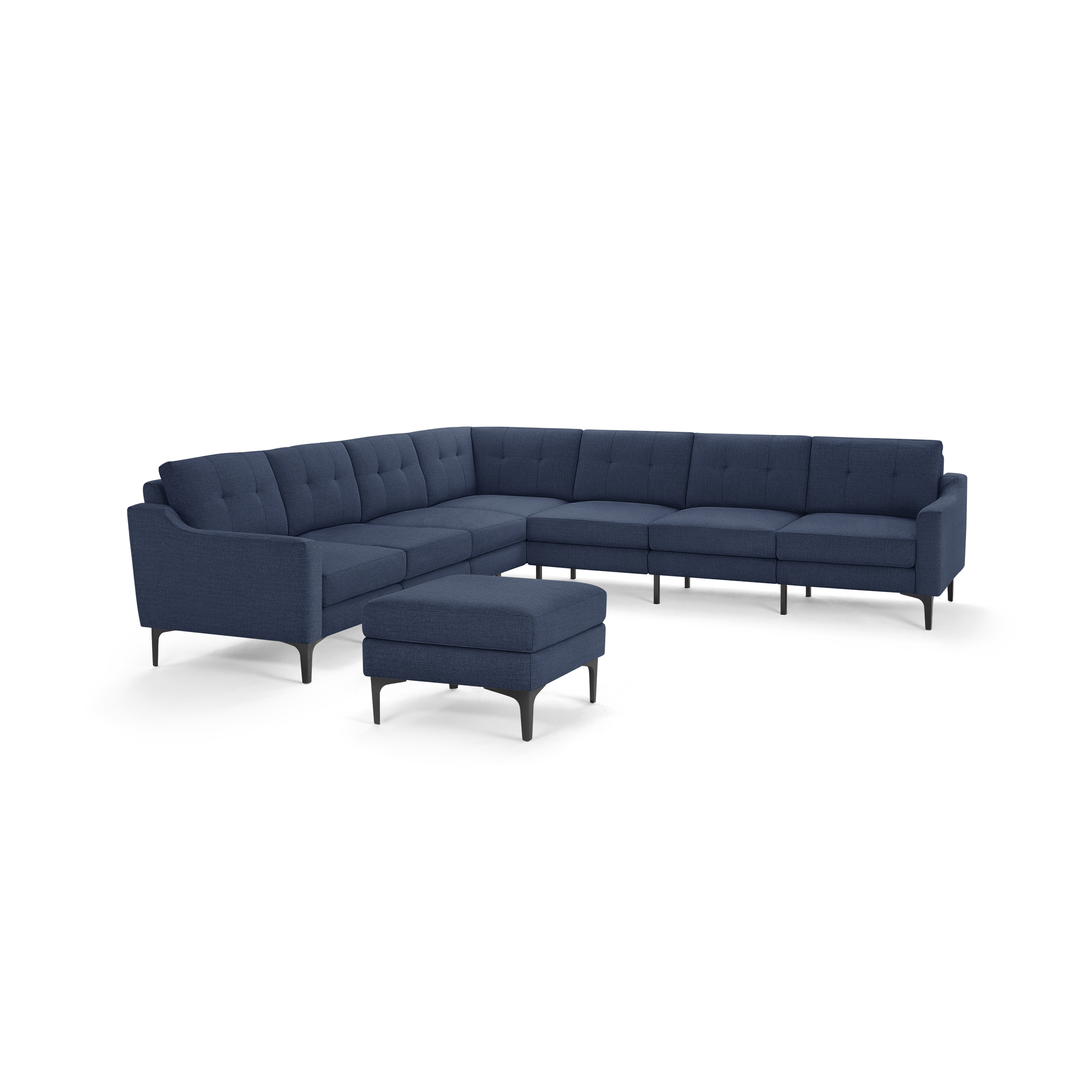 Modern L-shaped sectional sofa in dark blue fabric with tufted back cushions and matching ottoman, supported by slim black legs.