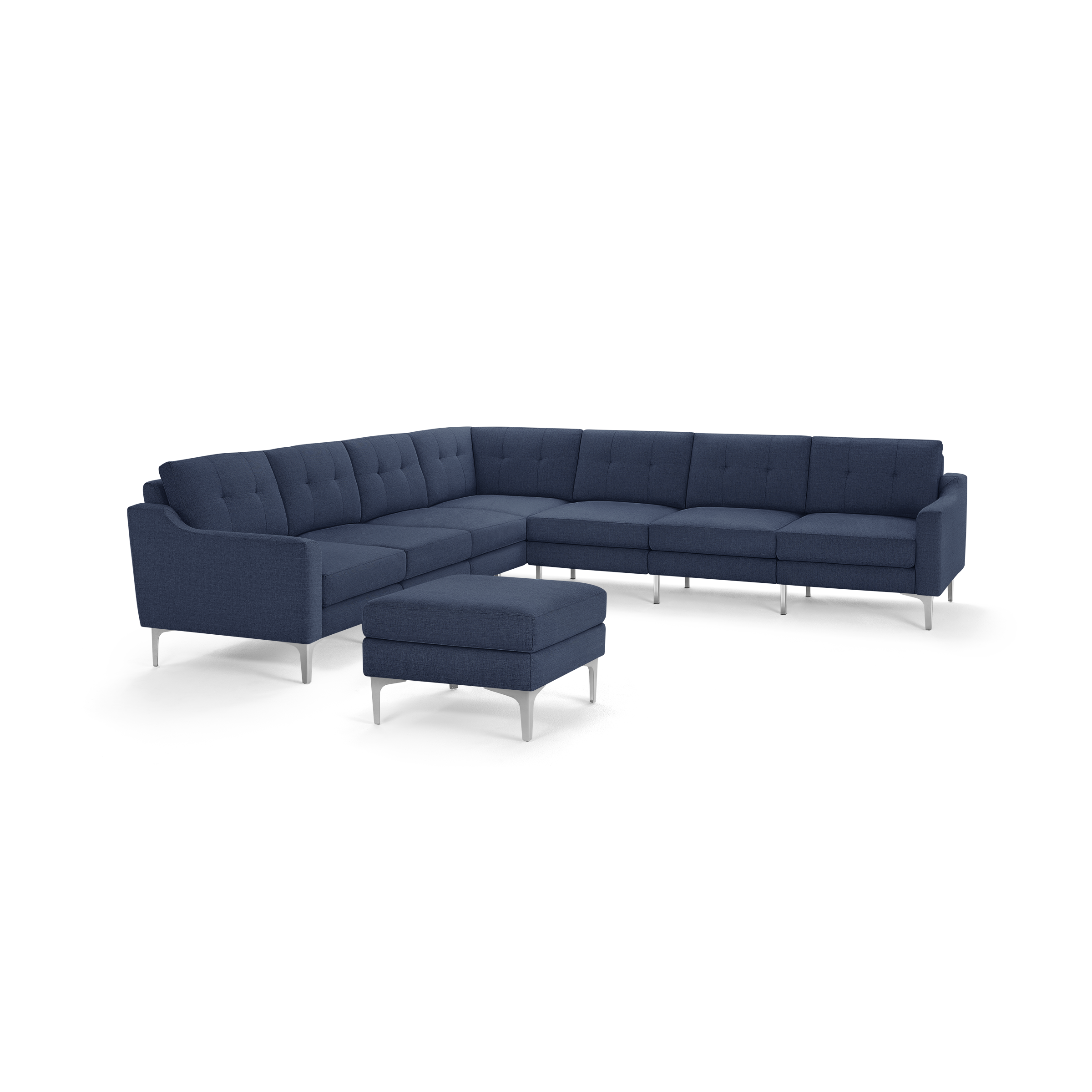Modern large L-shaped sectional sofa in dark blue fabric with tufted back cushions and matching ottoman on silver metal legs.