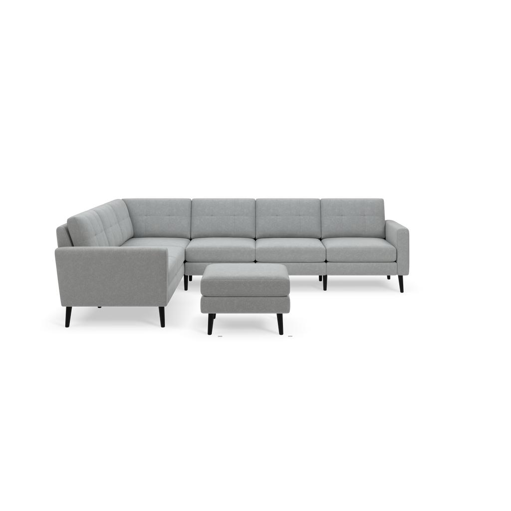 Light gray upholstered sectional sofa with tufted back cushions and matching ottoman on black legs, modern and minimalist design.