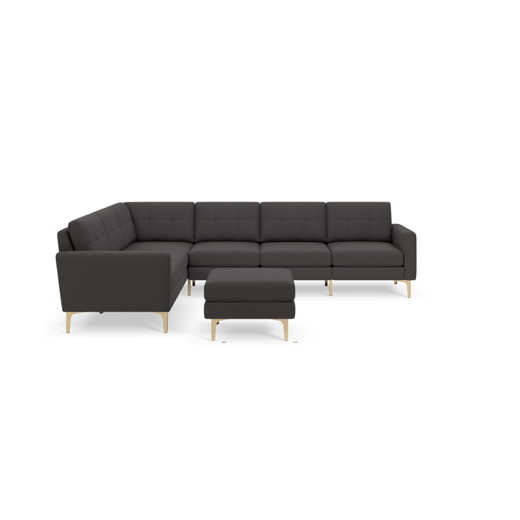 Dark gray L-shaped sectional sofa with tufted cushions, metal legs, and matching ottoman on black background.