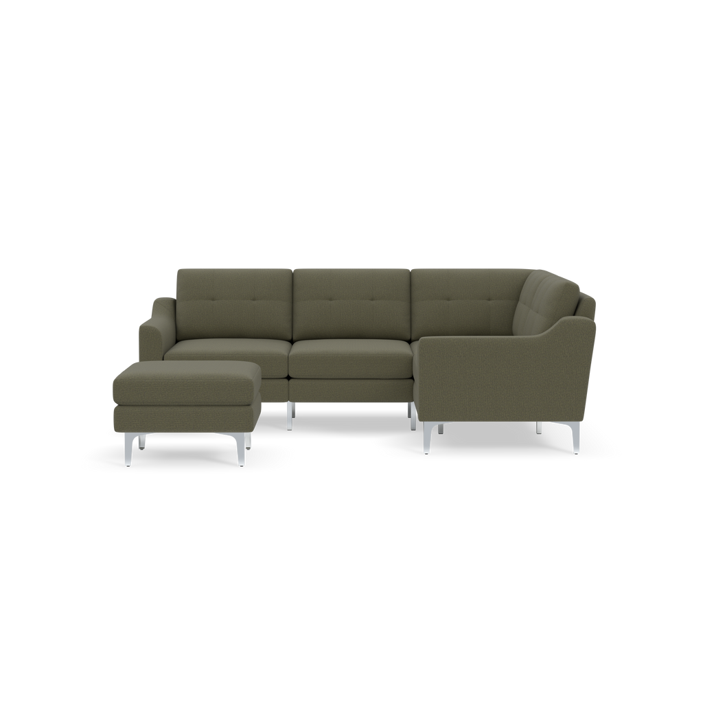 Olive green L-shaped sectional sofa with tufted cushions and matching ottoman on silver metal legs, isolated on black background.
