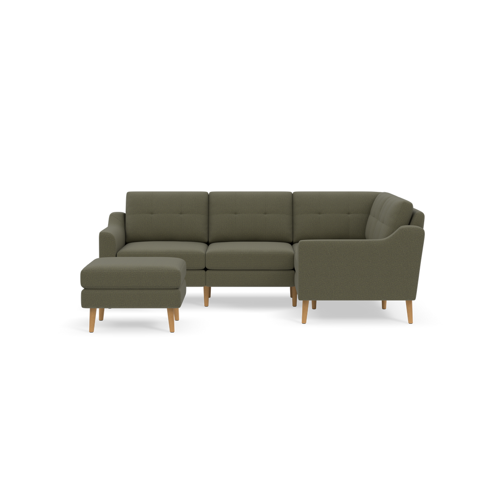Modern olive green fabric L-shaped sectional sofa with wooden legs and matching ottoman, displayed on black background.