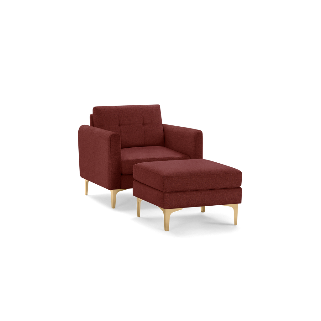 Modern maroon upholstered armchair with matching ottoman, both featuring light wooden legs and tufted backrest design.