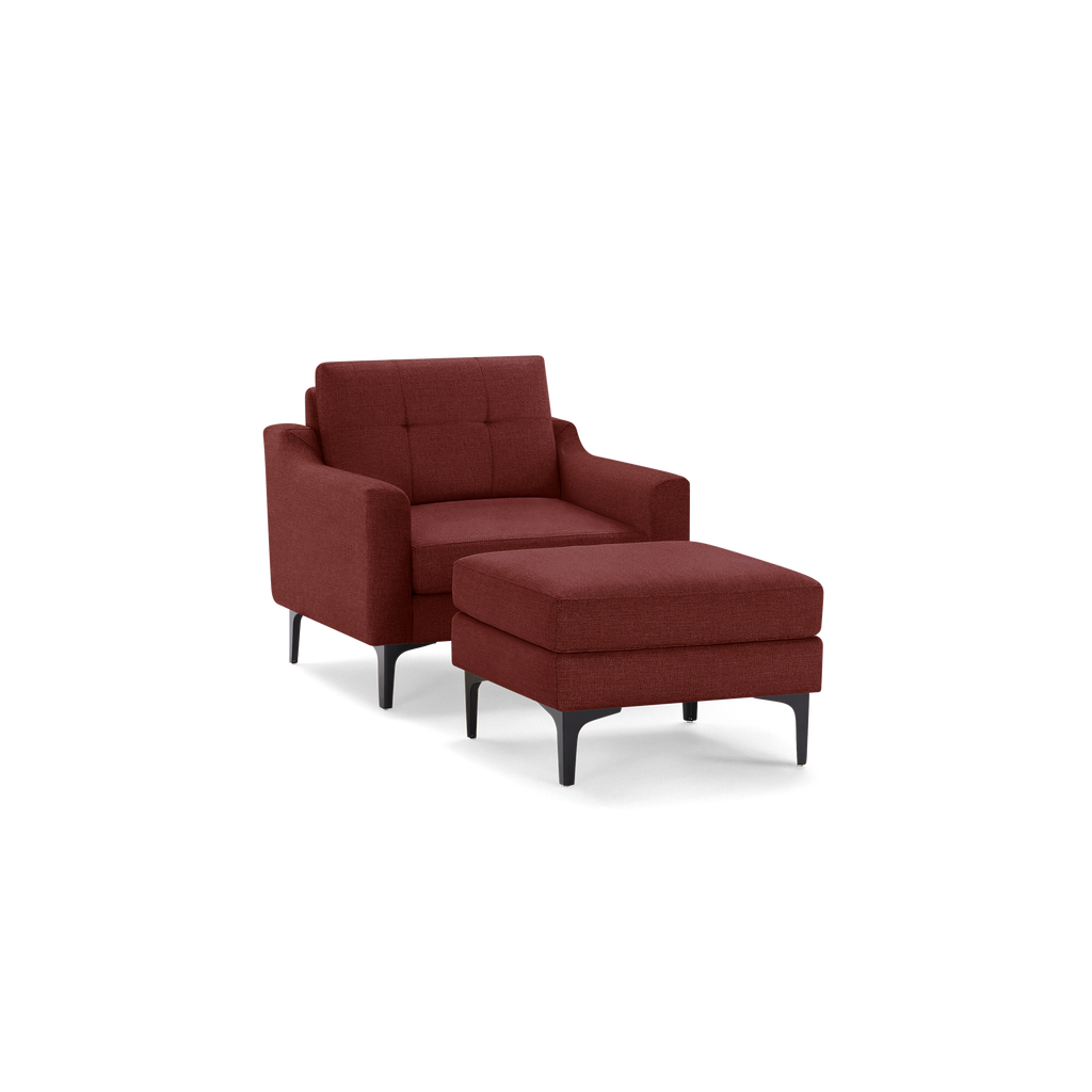 Modern burgundy upholstered armchair with matching ottoman, tufted backrest, and black metal legs.