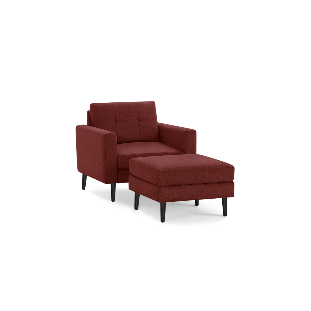 Modern red upholstered armchair with matching cushioned ottoman, both featuring black tapered legs and clean, minimalist design.