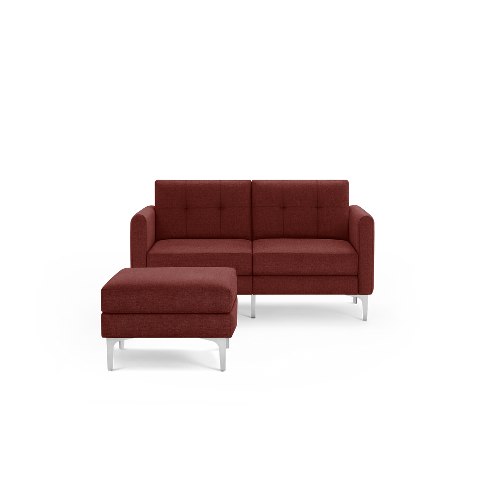 Modern two-piece sectional sofa and ottoman in deep red fabric with metal legs, featuring tufted back cushions.