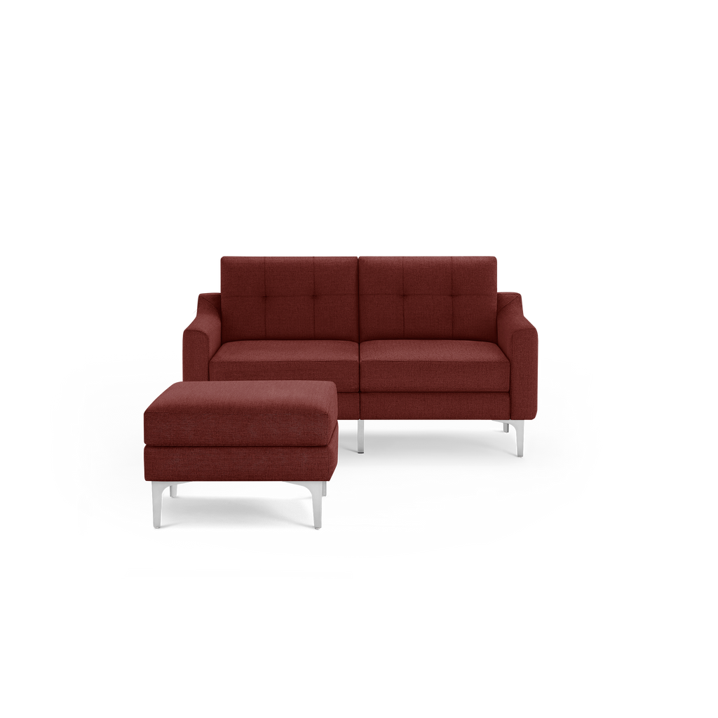 Modern dark red fabric loveseat sofa with button-tufted backrest, square arms, and a matching ottoman with silver metal legs.