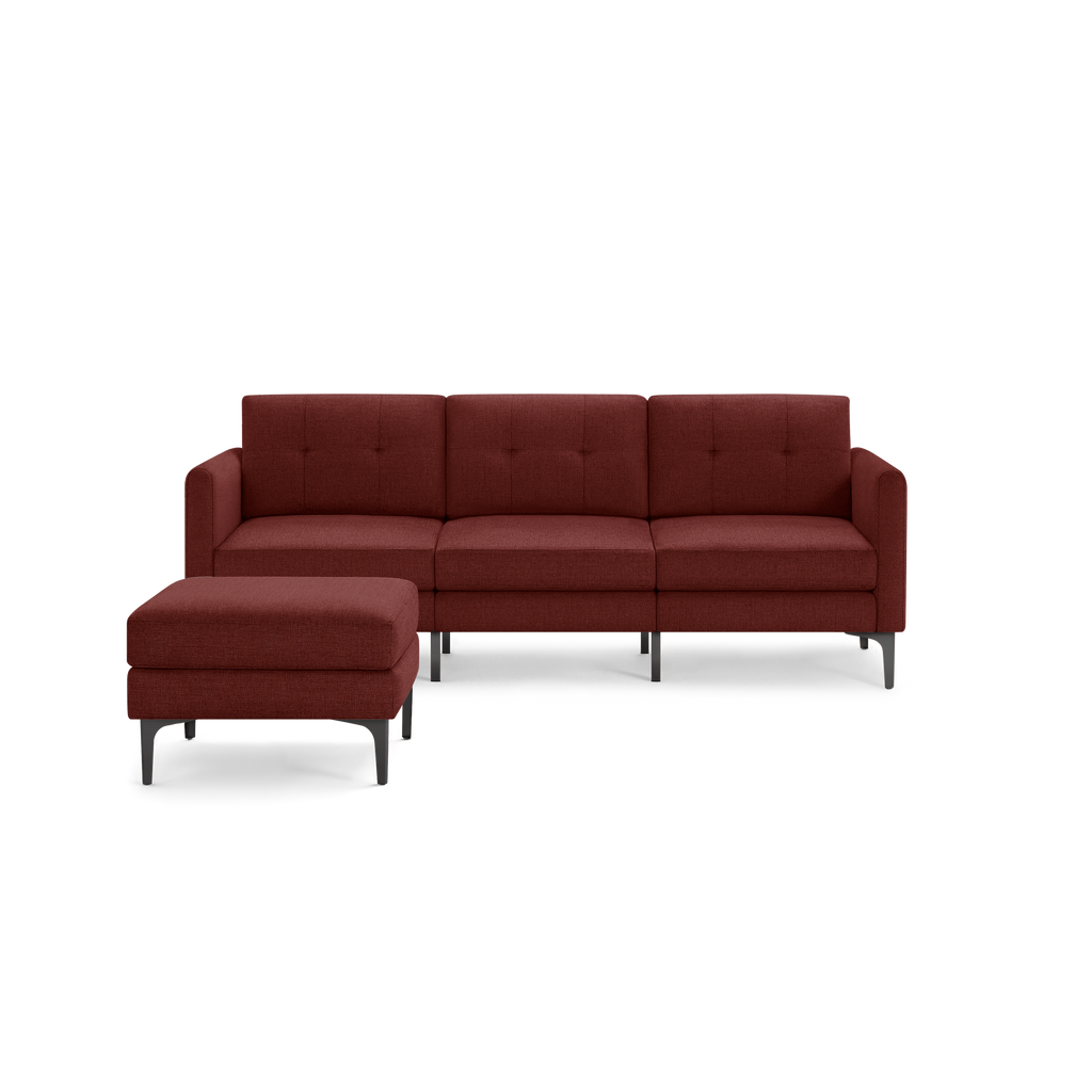 Mid-century modern sectional sofa with deep red upholstery and matching ottoman, featuring tufted cushions and sleek black metal legs.