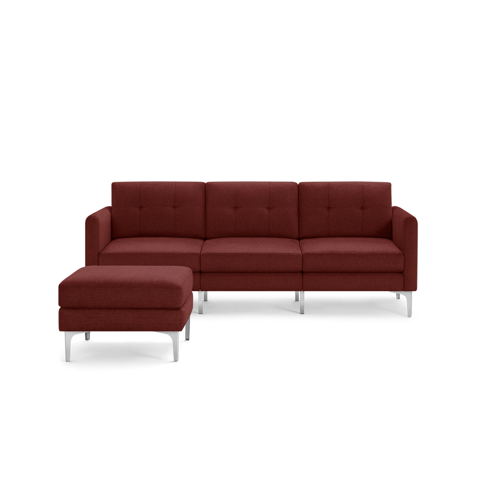 Modern sectional sofa with deep red fabric upholstery, tufted back cushions, and matching ottoman on sleek metal legs.