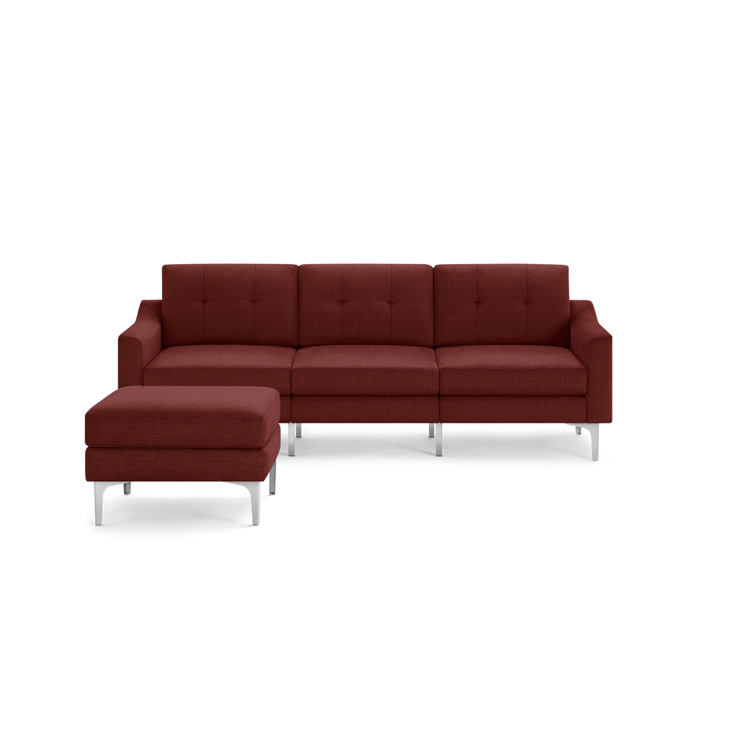 Modern sectional sofa in deep red fabric upholstery with tufted cushions, metal legs, and matching ottoman.