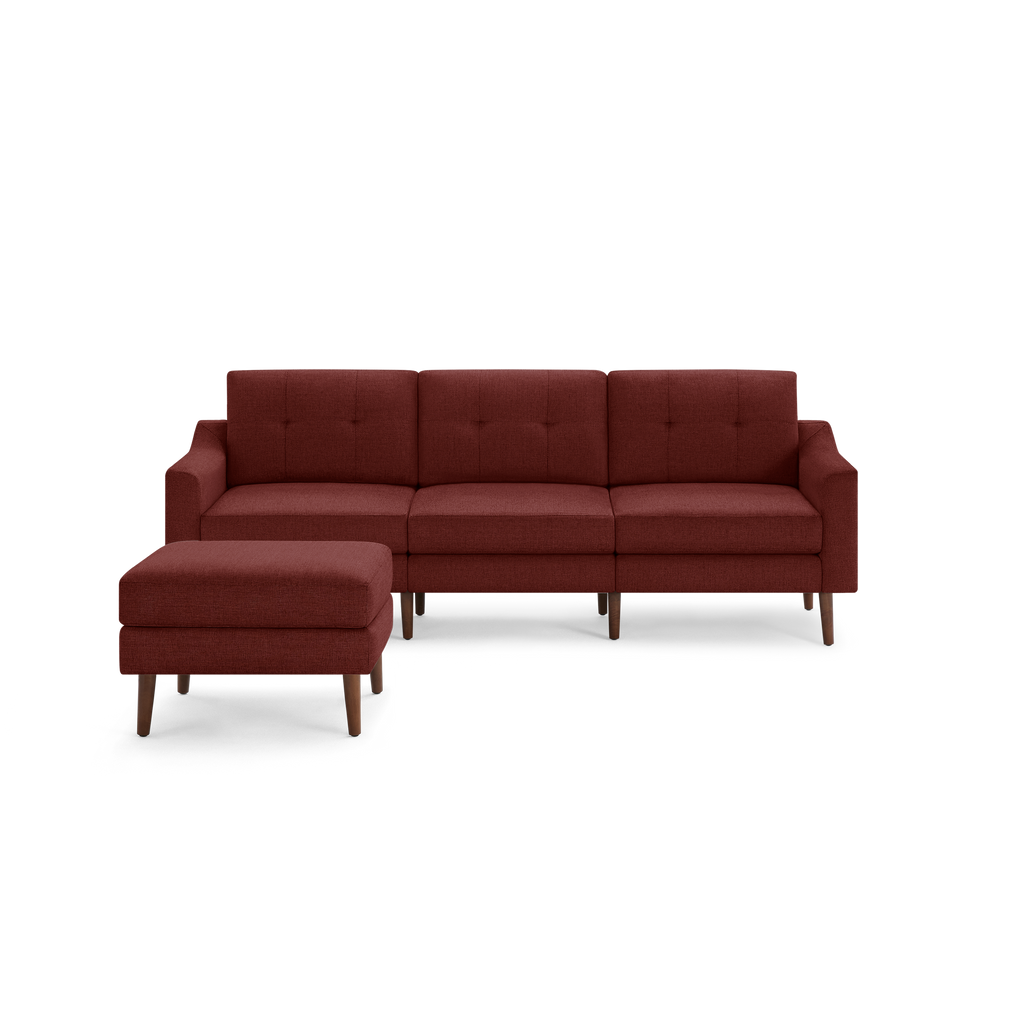 Modern sectional sofa with tufted back cushions and matching ottoman, upholstered in rich burgundy fabric with wooden legs.