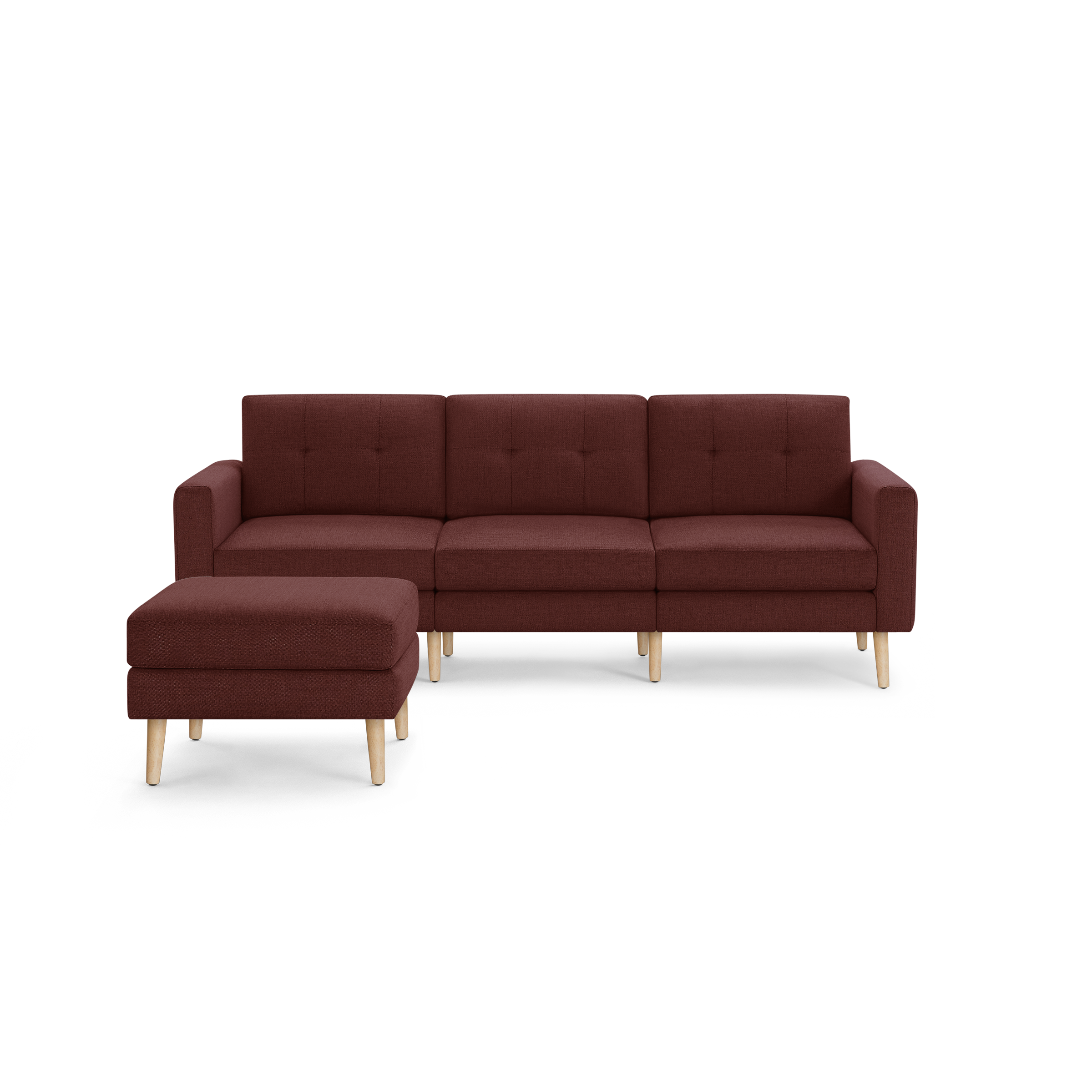 Modern three-seater burgundy fabric sofa with tufted back cushions and matching ottoman, featuring light wooden tapered legs.