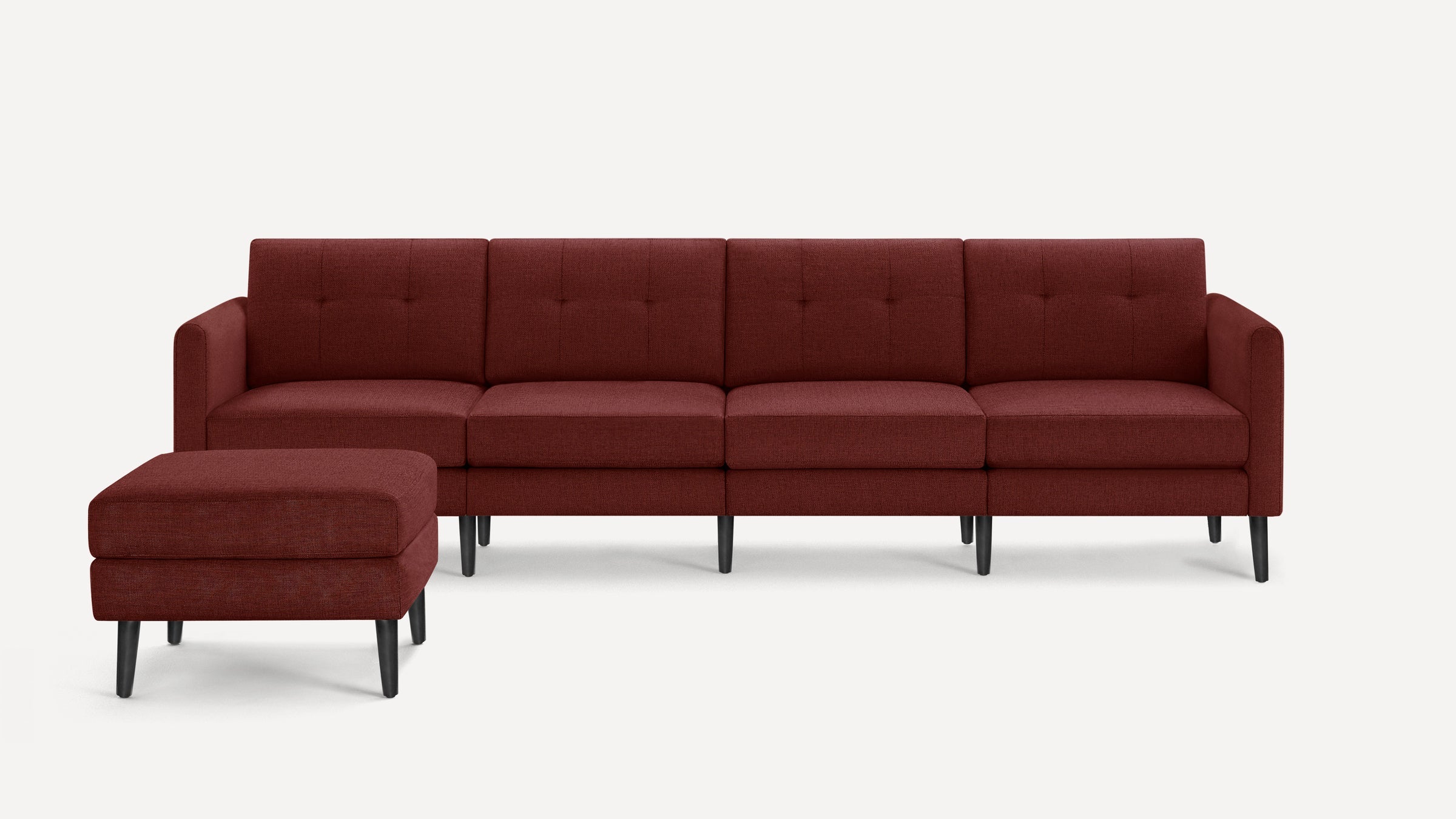 Four-seater modern sectional sofa in deep red fabric with matching ottoman and black tapered wooden legs.
