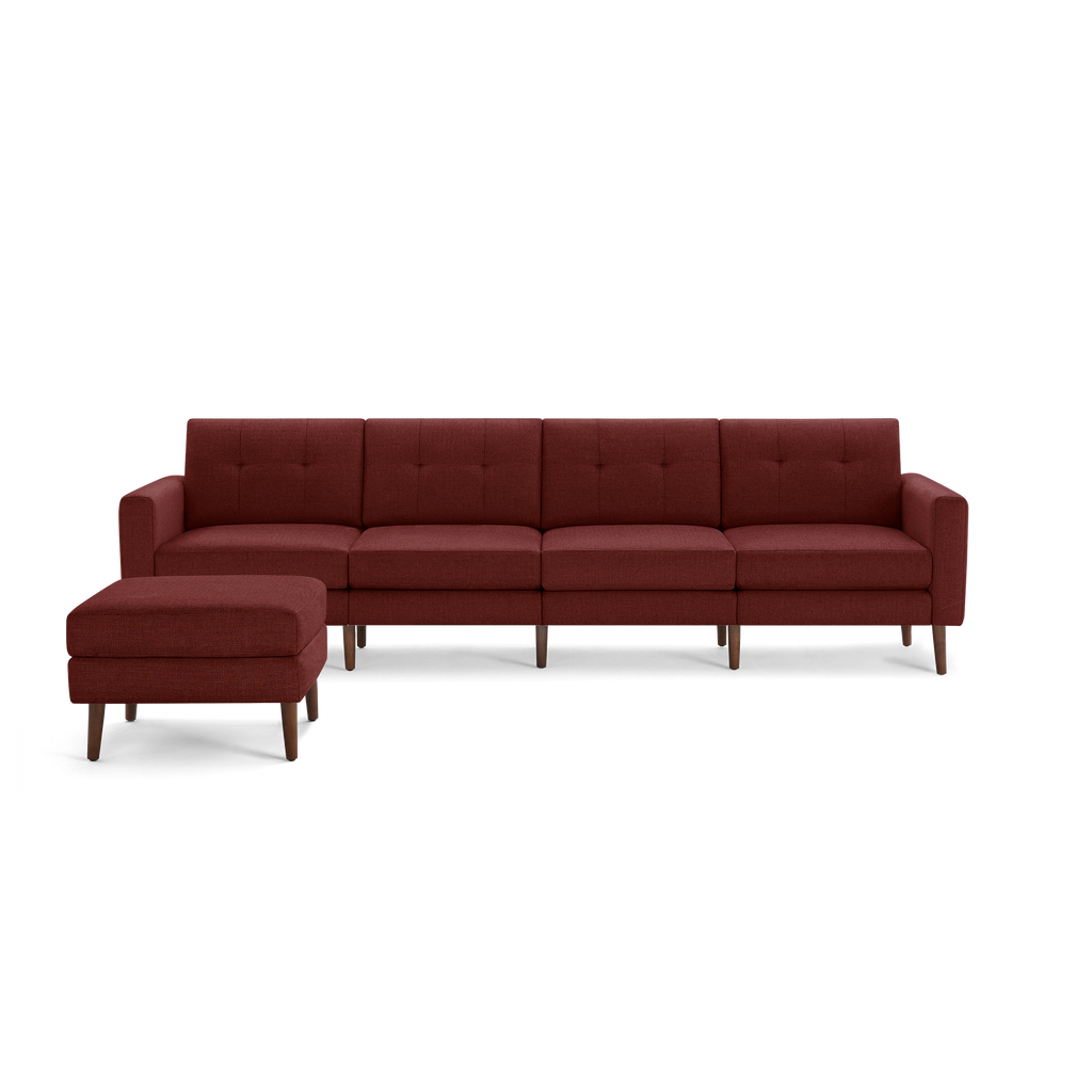 Modern sectional sofa with deep red upholstery, tufted back cushions, wooden legs, and matching ottoman.