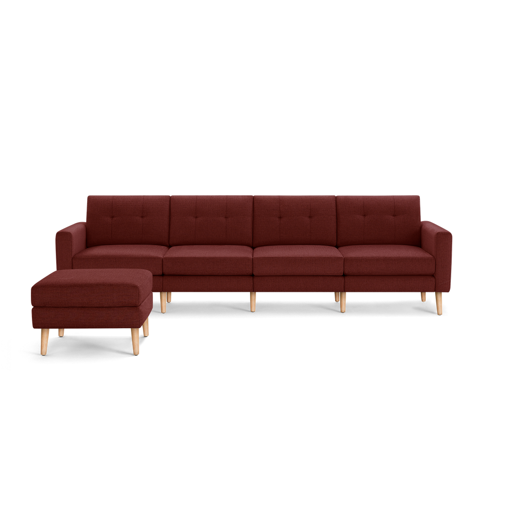 Burgundy fabric sectional sofa with tufted back cushions, wooden legs, and a matching ottoman.