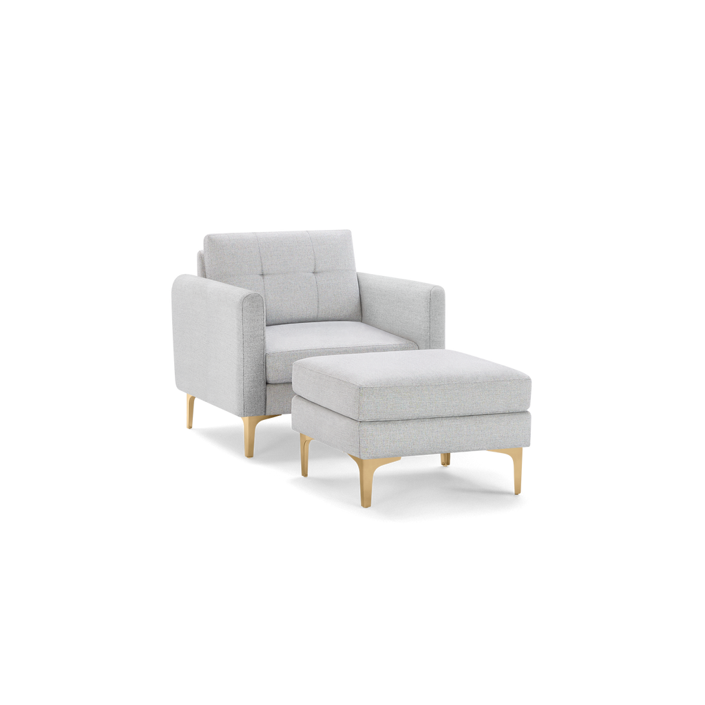 Light gray upholstered armchair and matching ottoman with wooden legs, featuring tufted backrest and cushioned seating.