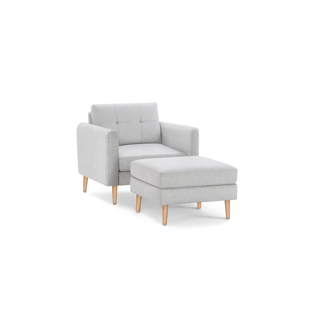 Light gray upholstered armchair with matching cushioned ottoman, featuring wooden legs and a modern, minimalist design.