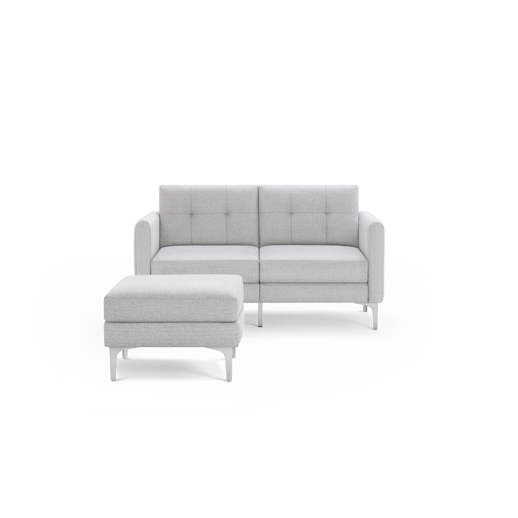 Light gray fabric loveseat with tufted back cushions and matching ottoman, supported by silver metal legs.