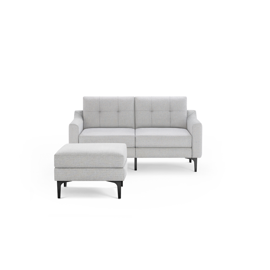 Light gray fabric loveseat with tufted back cushions and matching ottoman, supported by black metal legs.