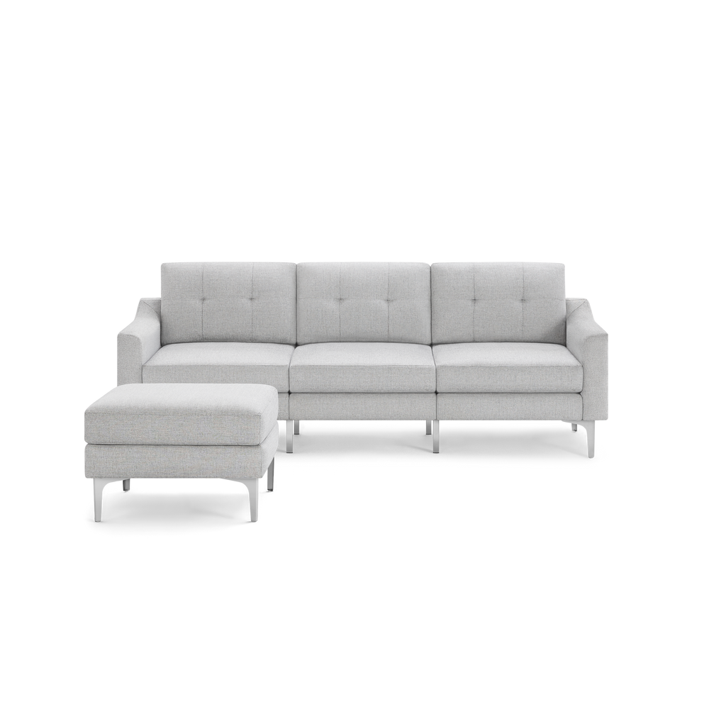 Modern light gray fabric sectional sofa with tufted cushions and a matching ottoman, featuring sleek metal legs.