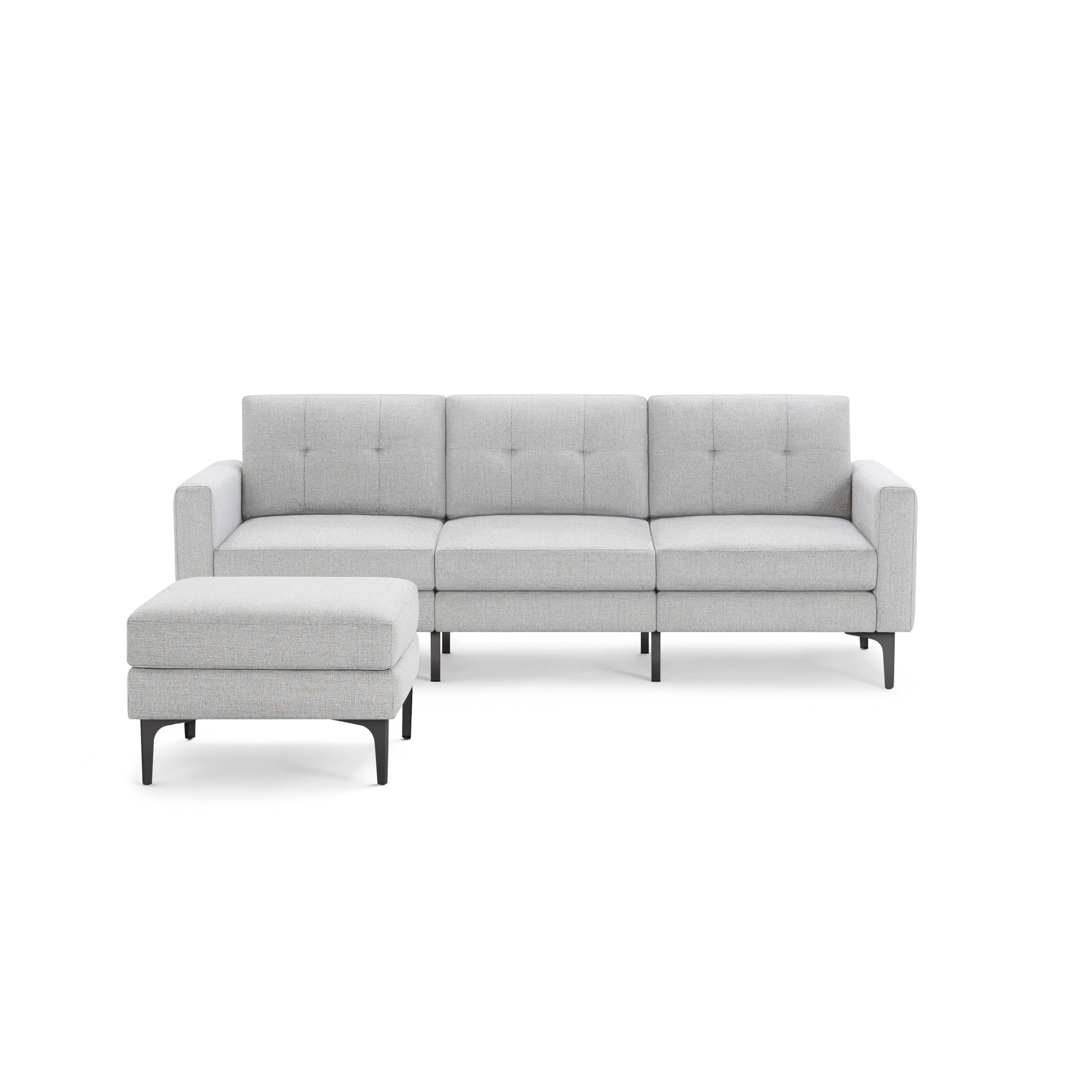 Light gray upholstered sectional sofa with tufted back cushions and matching ottoman, featuring slim black legs.
