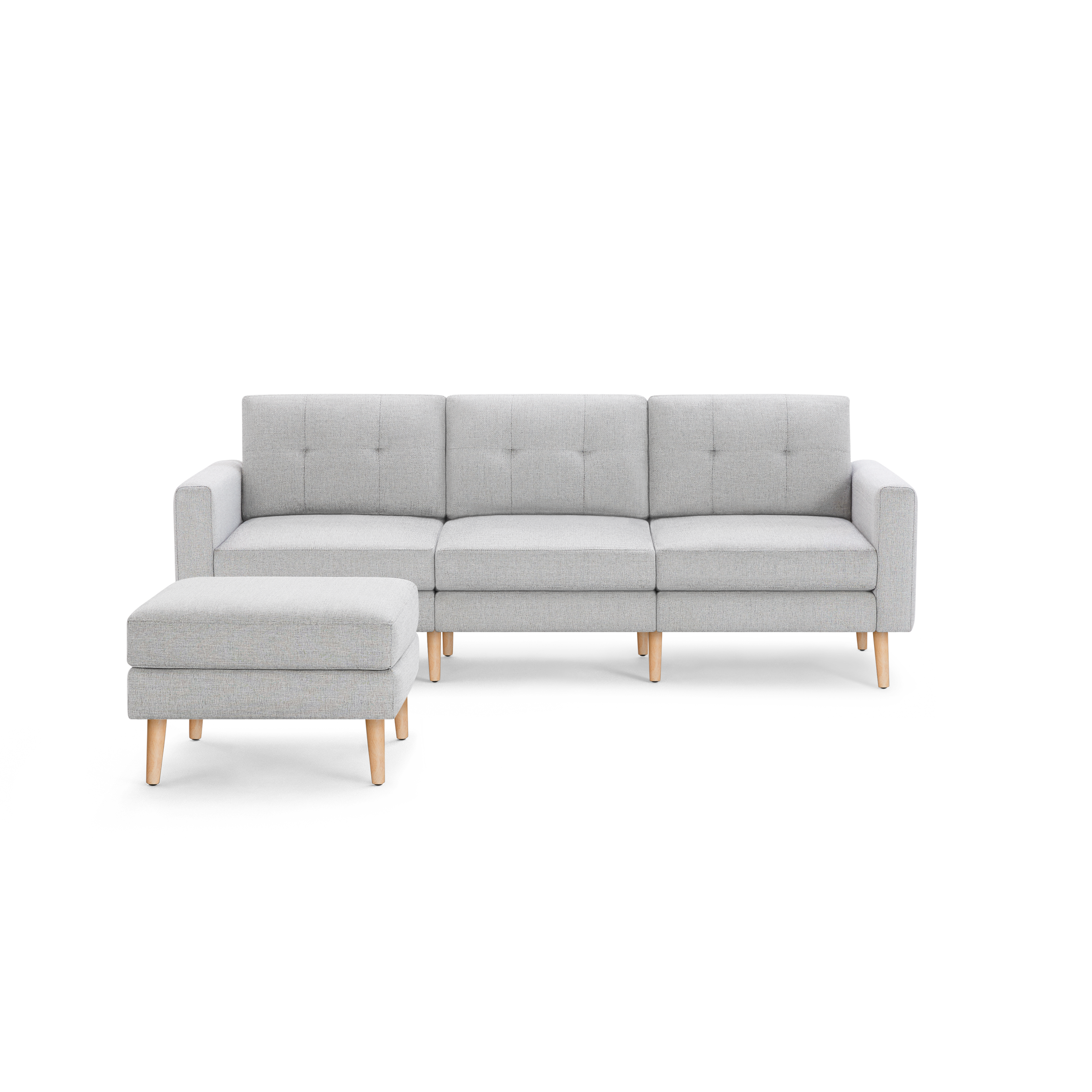 Light gray modern three-seater sofa with tufted backrests and matching ottoman, featuring wooden legs.