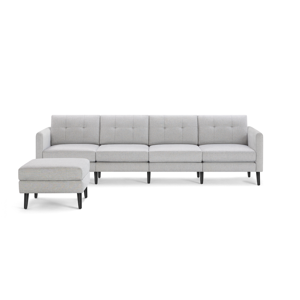 Light gray modern sectional sofa with tufted cushions and matching ottoman, supported by black wooden legs.
