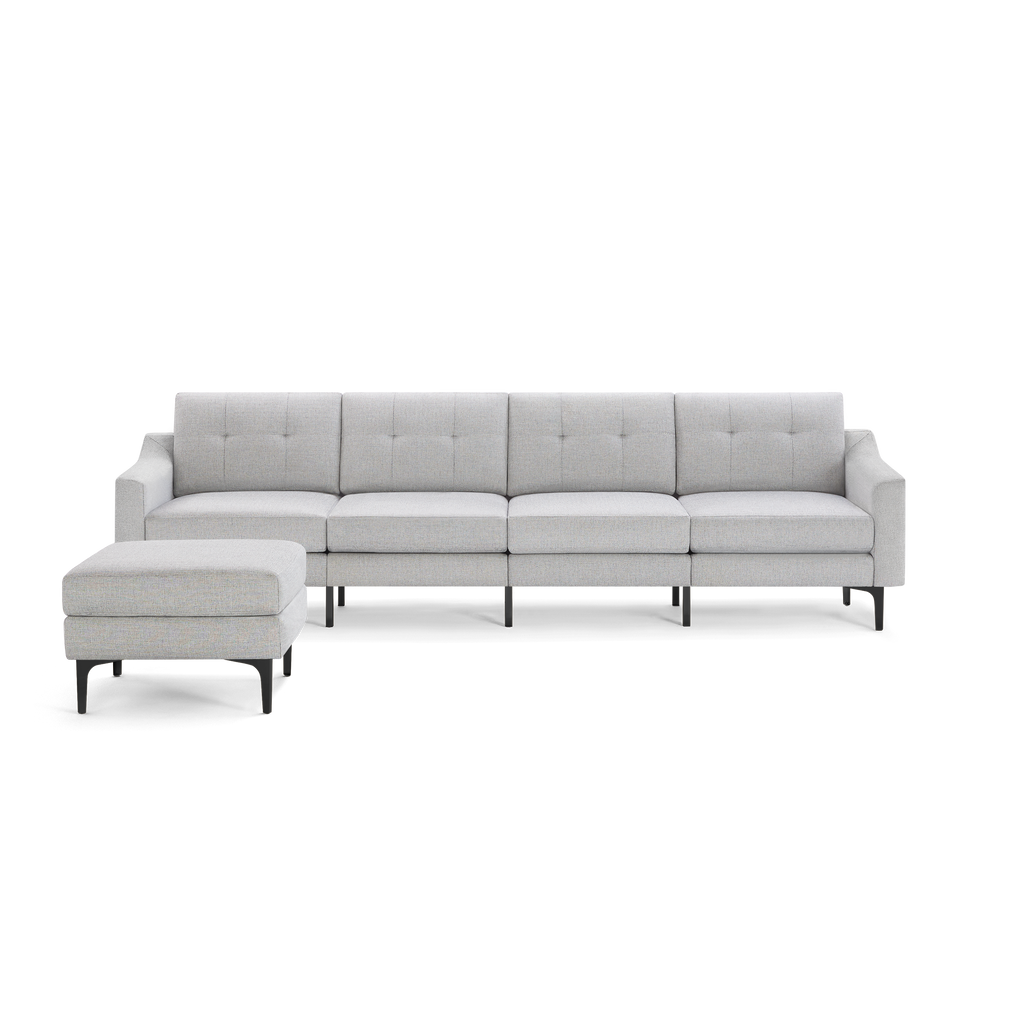 Light gray modern sectional sofa with button-tufted back cushions and matching ottoman, supported by slender black legs.